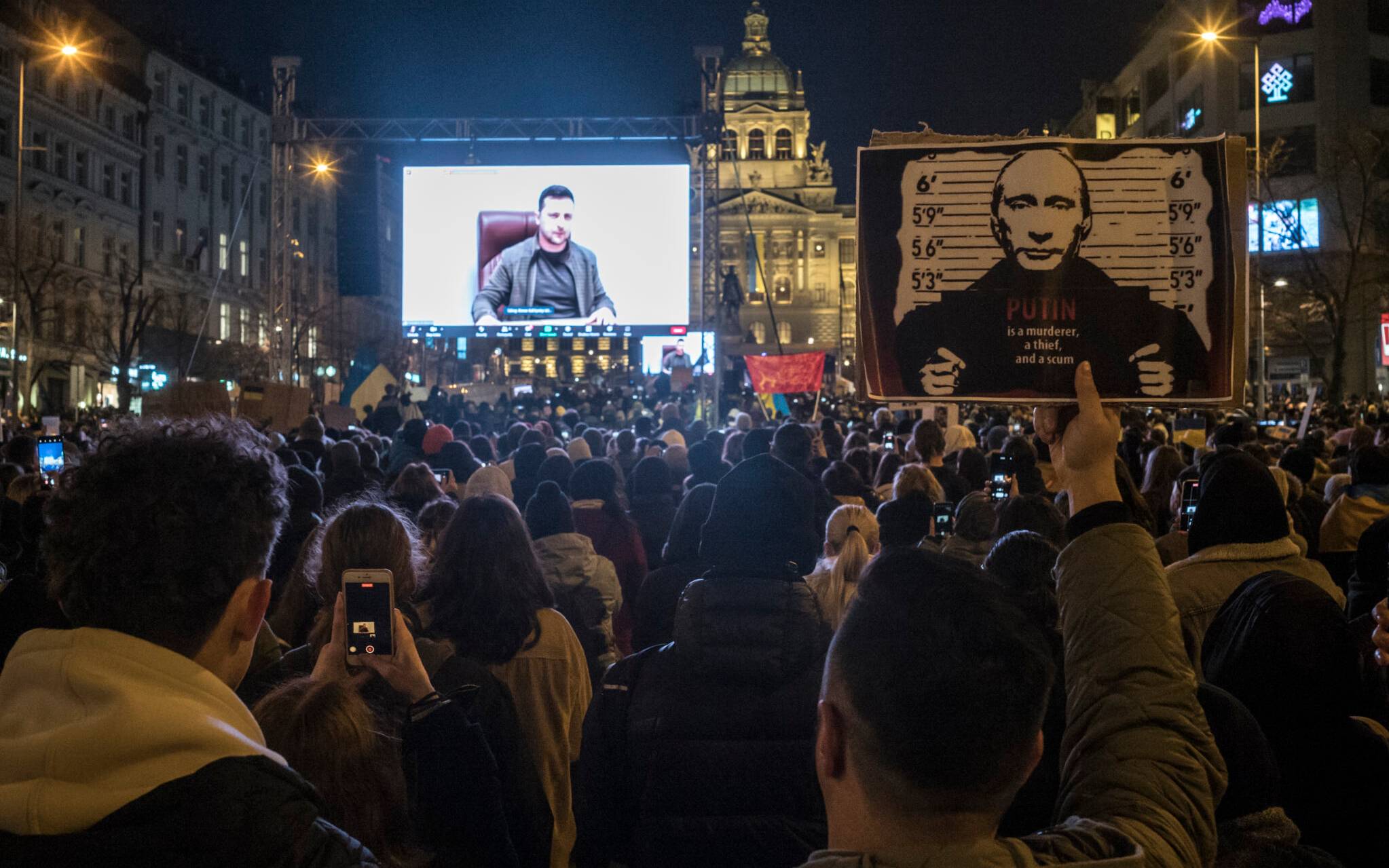 Protestors listen to a speech of Ukrainian President Volodymr Zelensky screened during a demonstration against Russia's invasion of Ukraine, on March 4, 2022 at the Venceslas square in Prague, Czech Republic. (Photo by Michal Cizek / AFP)