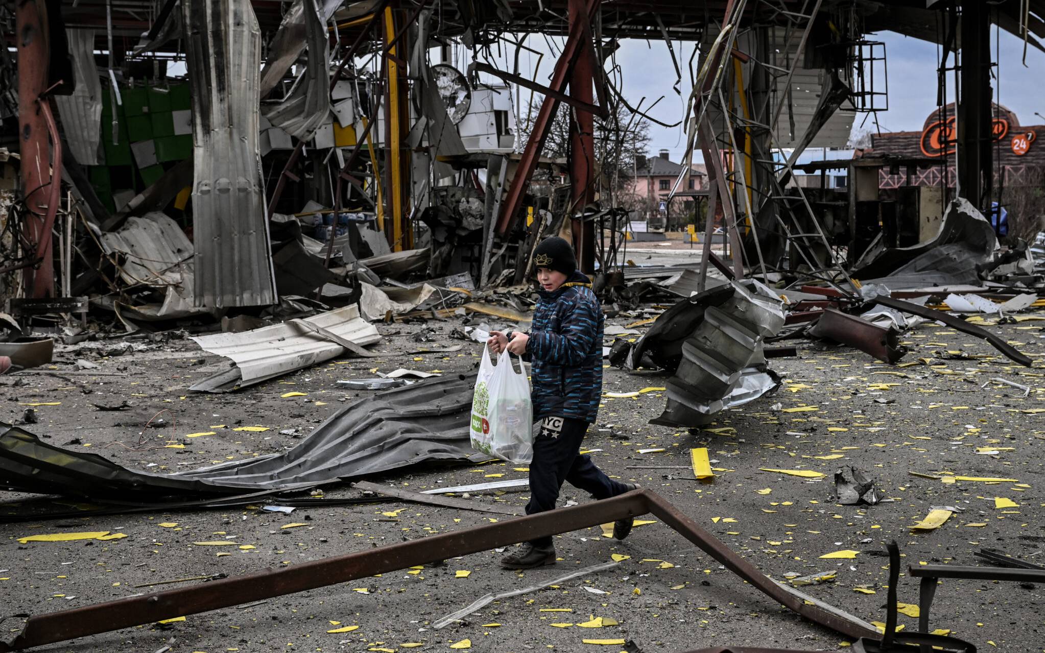 A child evacuates the city of Irpin, northwest of Kyiv, during heavy shelling and bombing on March 5, 2022, ten days after Russia launched a military invasion on Ukraine. (Photo by Aris Messinis / AFP)