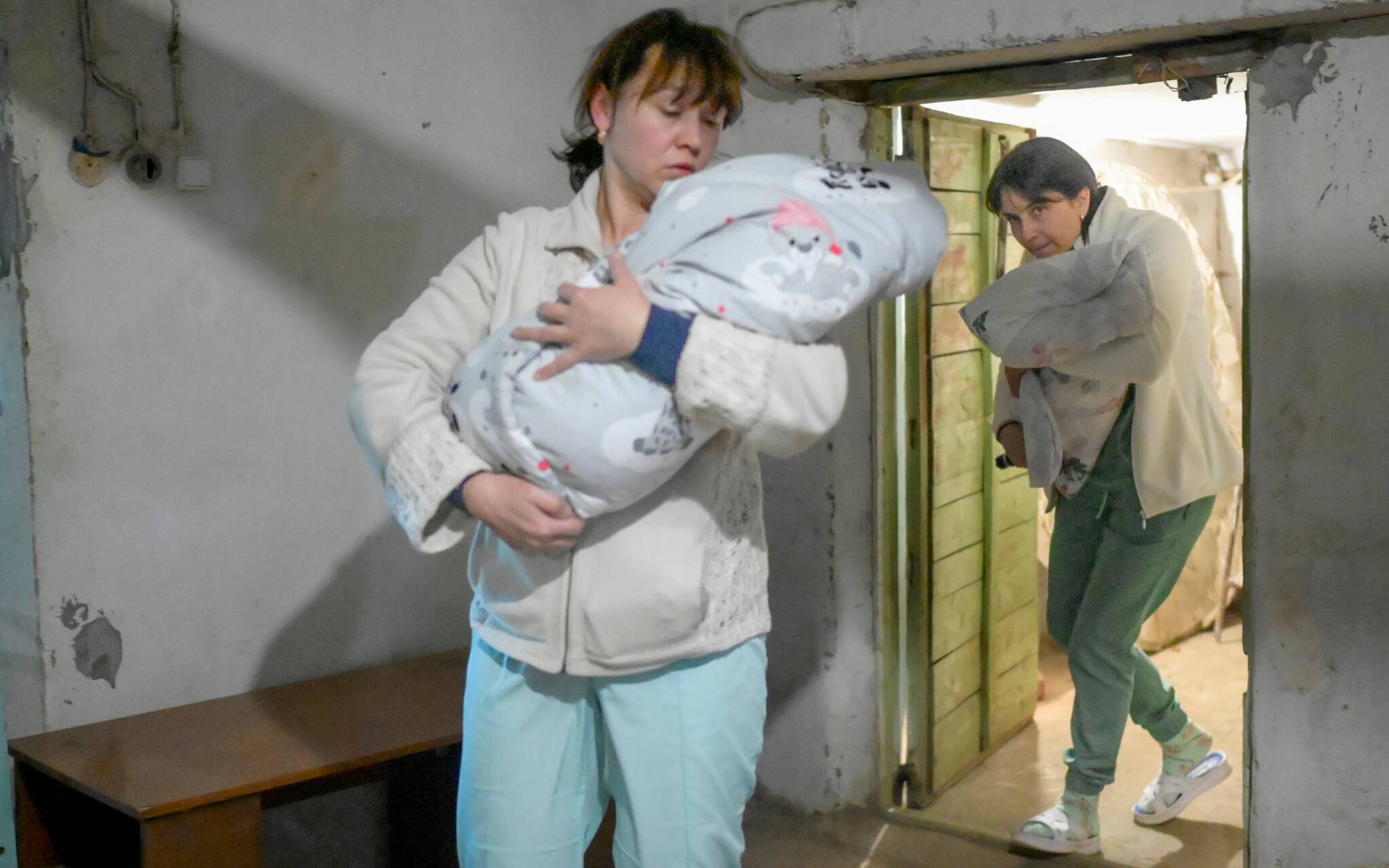 Nurses carry babies to the basement of maternity hospital as sirens warning for air raids in Mykolaiv, on March 14, 2022. - Almost half of the 49 women have had to give birth in the basement since 24 February. Mykolaïv is the scene of violent clashes, as Russian troops want to break down this last lock before the large port of Odessa, 130 km further west on the Black Sea. (Photo by BULENT KILIC / AFP)