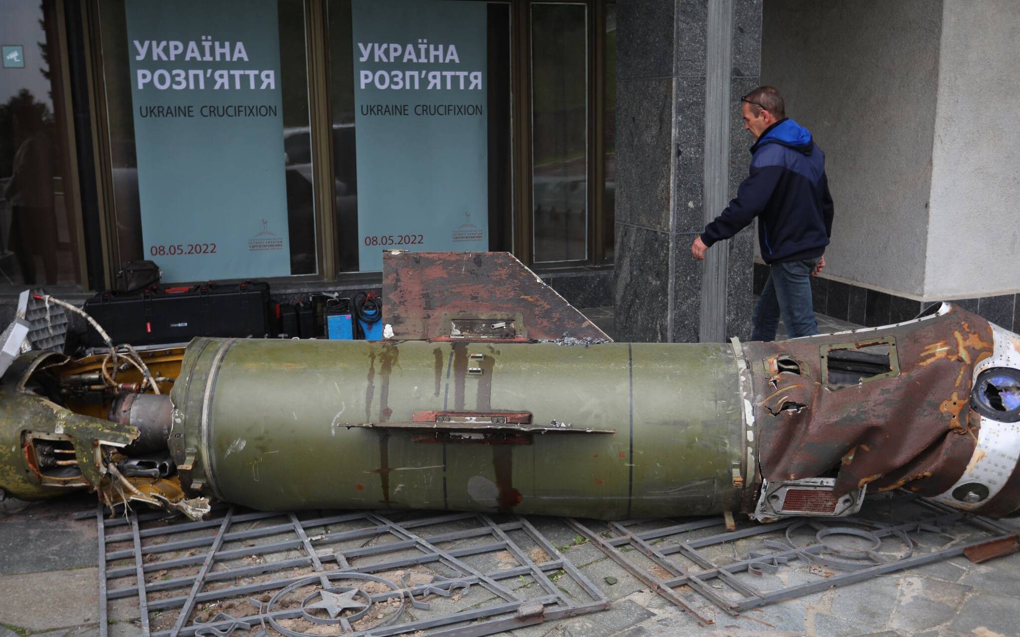 A visitor walks past the remains of a missile from the recent Ukraine Russia conflict, at the entrance to the World War II open-air museum in Kyiv on May 8, 2022, a day before 'Victory Day' is commemorated in Ukraine. (Photo by Aleksey Filippov / AFP)