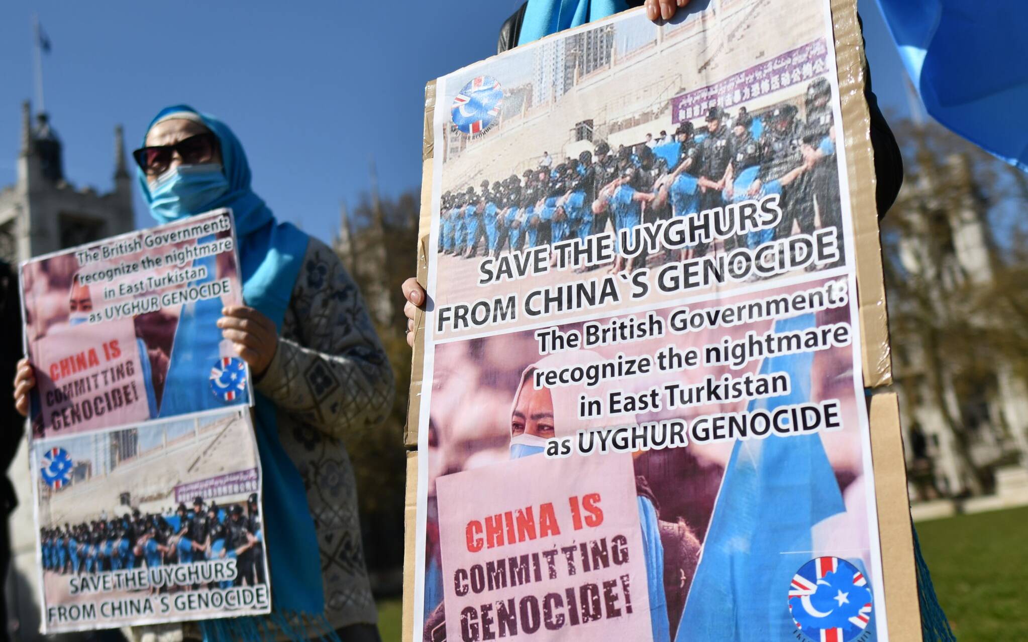Members of the Uyghur community hold placards as they demonstrate to call on the British parliament to vote to recognise alleged persecution of China's Muslim minority Uyghur people as genocide and crimes against humanity in London on April 22, 2021. - Lawmakers in the British Parliament will on April 22 debate a motion on alleged human rights abuses and persecution of China's Muslim Uyghur minority in the country's Xinjiang Autonomous Region. Last month Britain accused China of "gross human rights violations" against the  Uyghur minority after Beijing slapped sanctions on UK lawmakers and lobby groups, widening a rift with Western powers over alleged abuses in Xinjiang. (Photo by JUSTIN TALLIS / AFP)