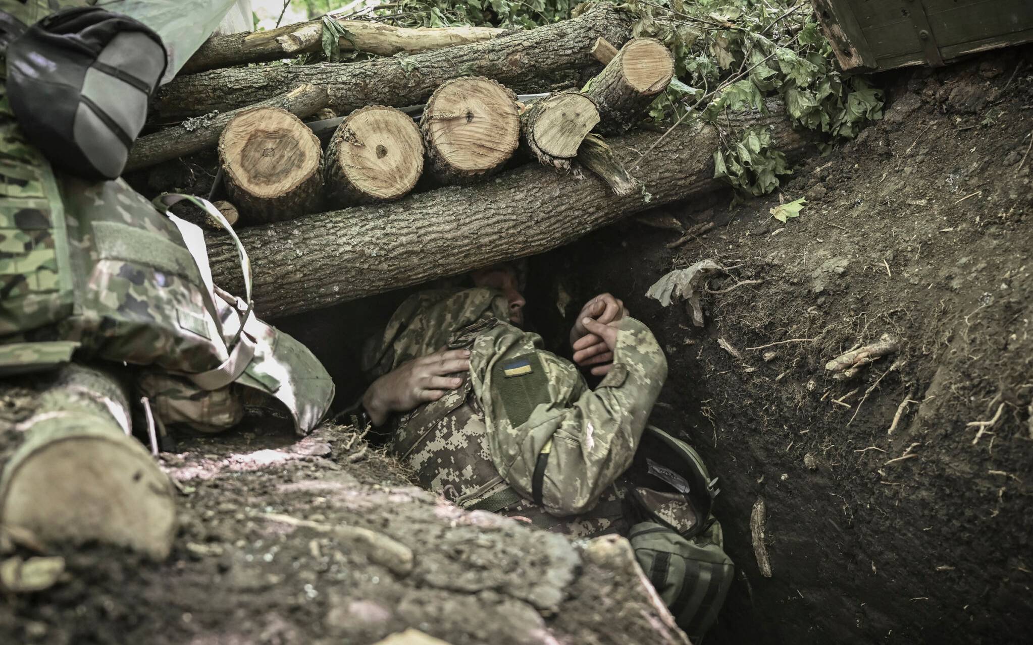 Ukrainian servicemen take cover during a shelling at a field camp near the front line at an undisclosed location in the eastern Ukrainian region of Donbas on June 6, 2022. (Photo by ARIS MESSINIS / AFP)