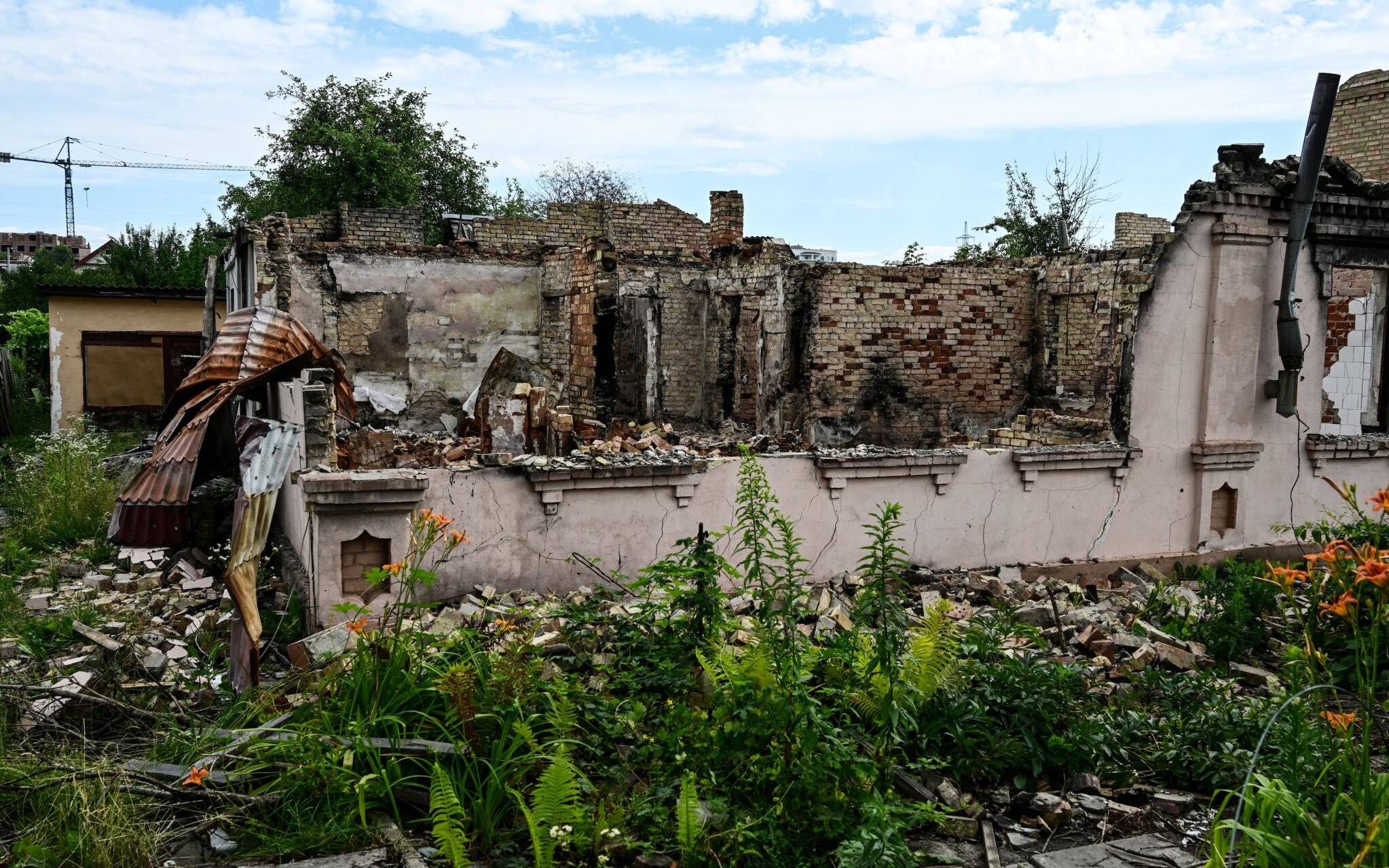 A picture taken on July 3, 2022 shows destroyed buildings in a residential area near Irpin, on Vokzalnaya street, which links the Ukrainian cities of Bucha and Irpin, amid the Russian invasion of Ukraine. - Three months have passed since AFP journalists discovered, on April 2, in Yablunska Street, 20 bodies of slaughtered civilians, the first indications of the atrocities and destruction committed during the Russian occupation of these suburbs of northwestern Kiev, once prized for their calm and proximity to nature. (Photo by Miguel MEDINA / AFP)