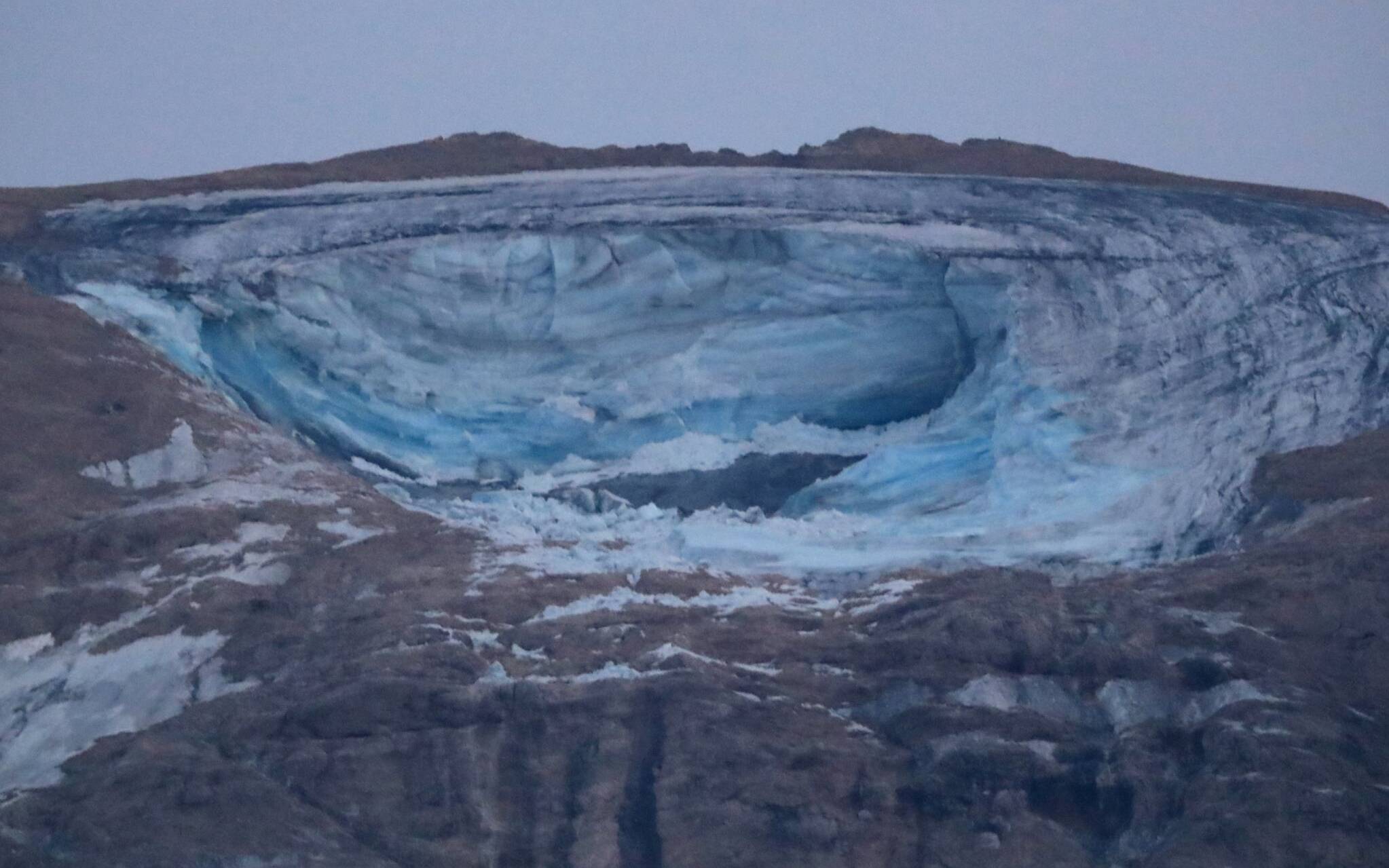 This photograph taken on July 3, 2022 from Canazei, shows the ice serac that collapsed on the Marmolada, near Punta Rocca, killing six people. - An avalanche set off by the collapse of the largest glacier in the Italian Alps killed at least six people and injured eight others on July 3, 2022, an emergency services spokeswoman said. The glacier collapsed on the mountain of Marmolada, the highest in the Italian Dolomites, near the hamlet of Punta Rocca, on the route normally taken to reach its summit. (Photo by Pierre TEYSSOT / AFP)