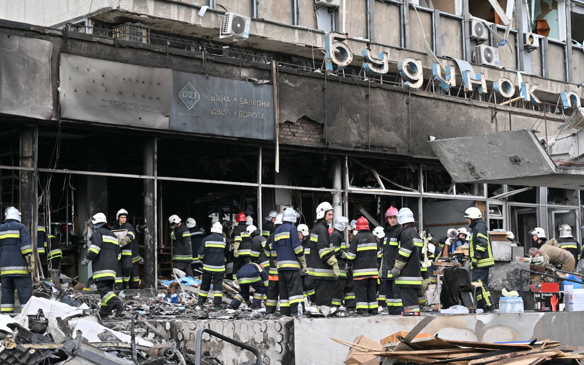 Firefighters remove rubbles out of a damaged building following a Russian airstrike in the city of Vinnytsia, west-central Ukraine on July 14, 2022. - At least 20 people were killed Thursday by Russian strikes on a city in central Ukraine, bombings described as "an openly terrorist act" by Ukrainian President Volodymyr Zelensky. (Photo by Sergei SUPINSKY / AFP)