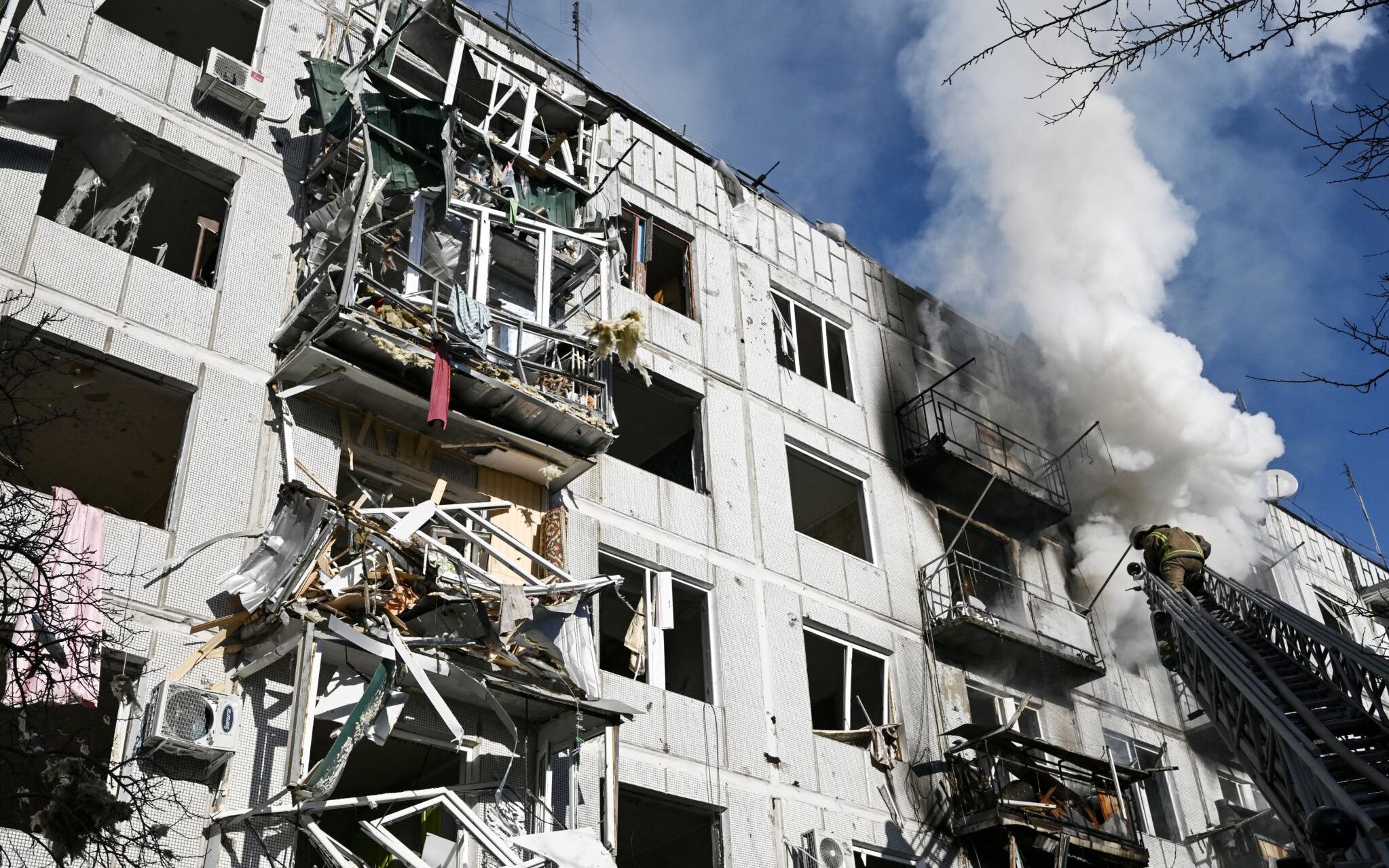 Firefighters work on a fire on a building after bombings on the eastern Ukraine town of Chuguiv on February 24, 2022, as Russian armed forces are trying to invade Ukraine from several directions, using rocket systems and helicopters to attack Ukrainian position in the south, the border guard service said. - Russia's ground forces on Thursday crossed into Ukraine from several directions, Ukraine's border guard service said, hours after President Vladimir Putin announced the launch of a major offensive. Russian tanks and other heavy equipment crossed the frontier in several northern regions, as well as from the Kremlin-annexed peninsula of Crimea in the south, the agency said. (Photo by Aris Messinis / AFP)