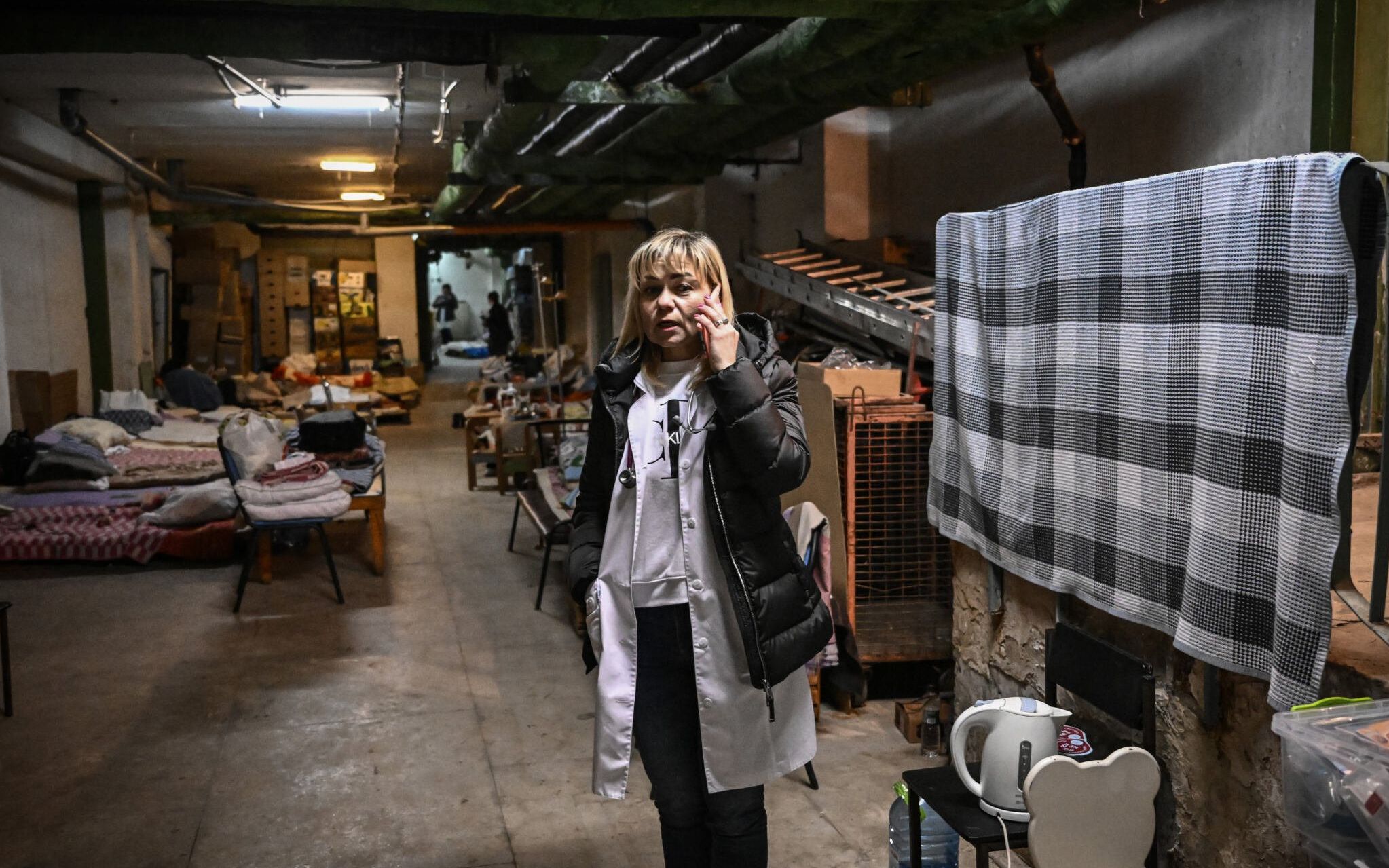 A doctor speaks on the phone as she stands in the newly located pediatrics center after it were moved to the basement of the hospital which is being used as a bomb shelter, in Kyiv on February 28, 2022. - The Russian army said on February 28, 2022, that Ukrainian civilians could "freely" leave the country's capital Kyiv and claimed its airforce dominated Ukraine's skies as its invasion entered a fifth day. (Photo by Aris Messinis / AFP)