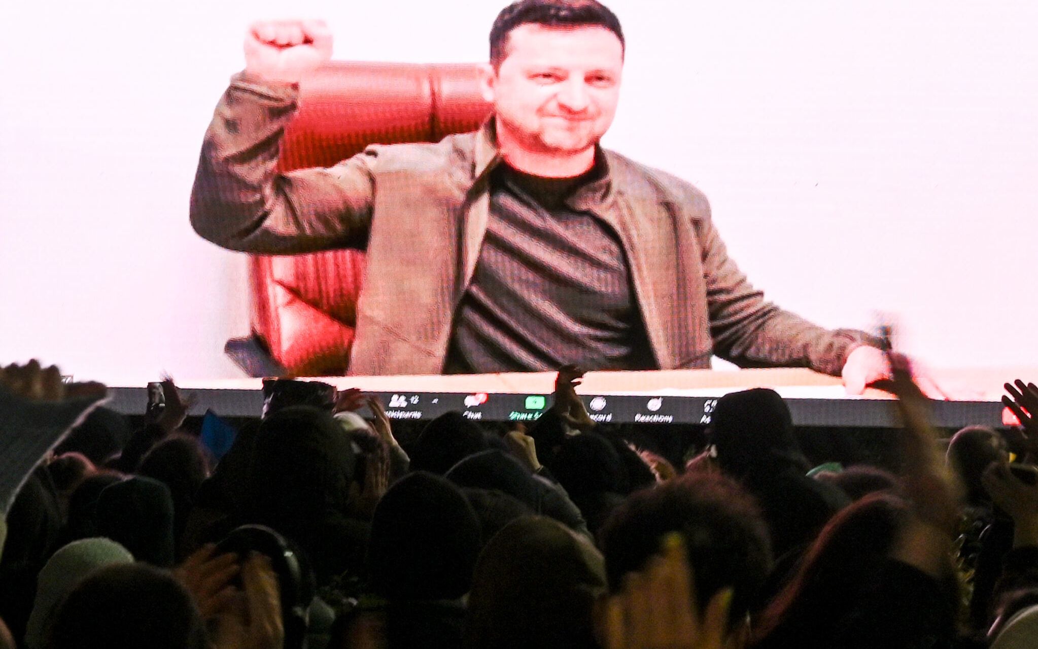 Demonstrators watch an address of Ukrainian President Volodymyr Zelensky on the big screen during a rally in support of Ukraine in Tbilisi on March 4, 2022. (Photo by Vano SHLAMOV / AFP)