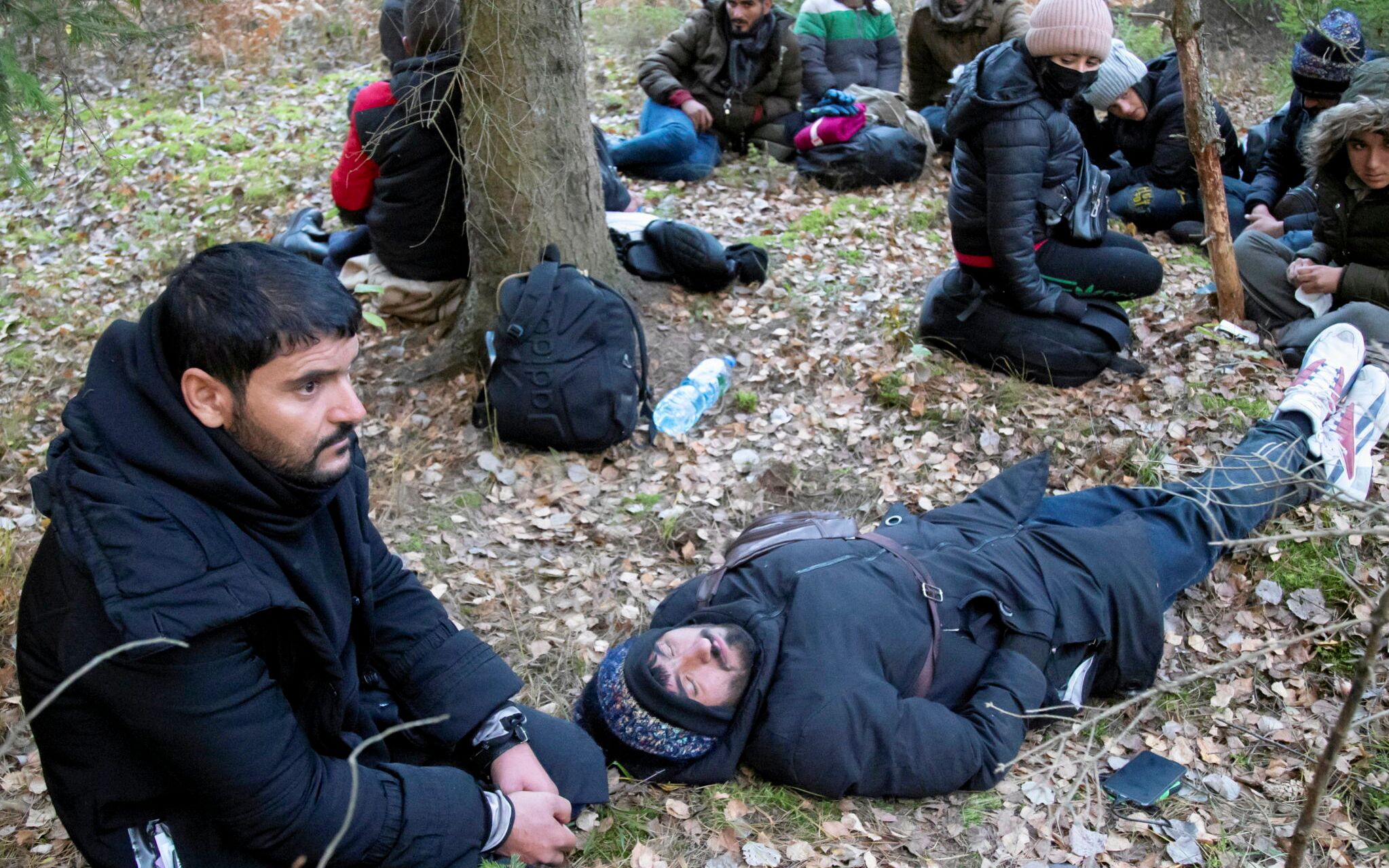 16.10.2021 okolice Bachur . Grupa 13 Jazydow z irackiego Kurdystanu w lesie poza strefa stanu wyjatkowego . Przeszli zielona granice od strony Bialorusi . Od kilkunastu dni sa w lesie , po kulkukrotnym push back - u . Od wolontariuszek z grupy Ocalenie otrzymali pomoc humanitarna - jedzenie , wode , ubrania , opatrunki na rany stop . Od mieszkanca okolicy i jego rodziny otrzymali cieple jedzenie , skarpety , ubrania , poniewaz byli przemoczeni i zmarznieci . 
Fot. Agnieszka Sadowska / Agencja Wyborcza.pl *** Local Caption *** .