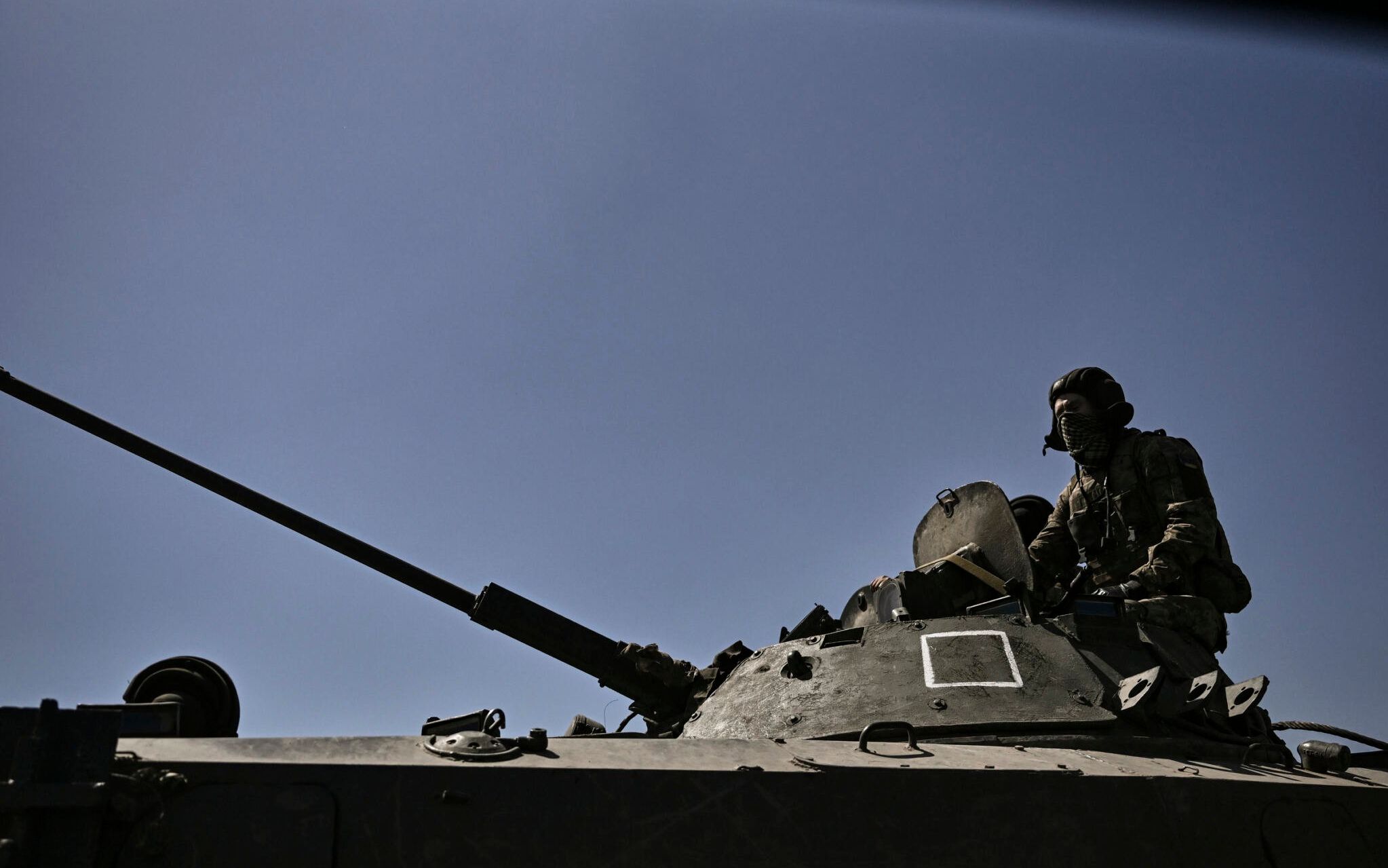 A member of the Ukrainian troops stands on an armoured vehicle moving towards the front line in the city of Lysychansk in the eastern Ukraine region of Donbas on June 9, 2022, as Russian forces have for weeks been concentrating their firepower on Severodonetsk and its sister city of Lysychansk across the river. - A defiant Lugansk governor declares that Ukrainian forces could reclaim Severodonetsk "in two to three days" if they receive long-range artillery promised by the US and Britain. (Photo by ARIS MESSINIS / AFP)