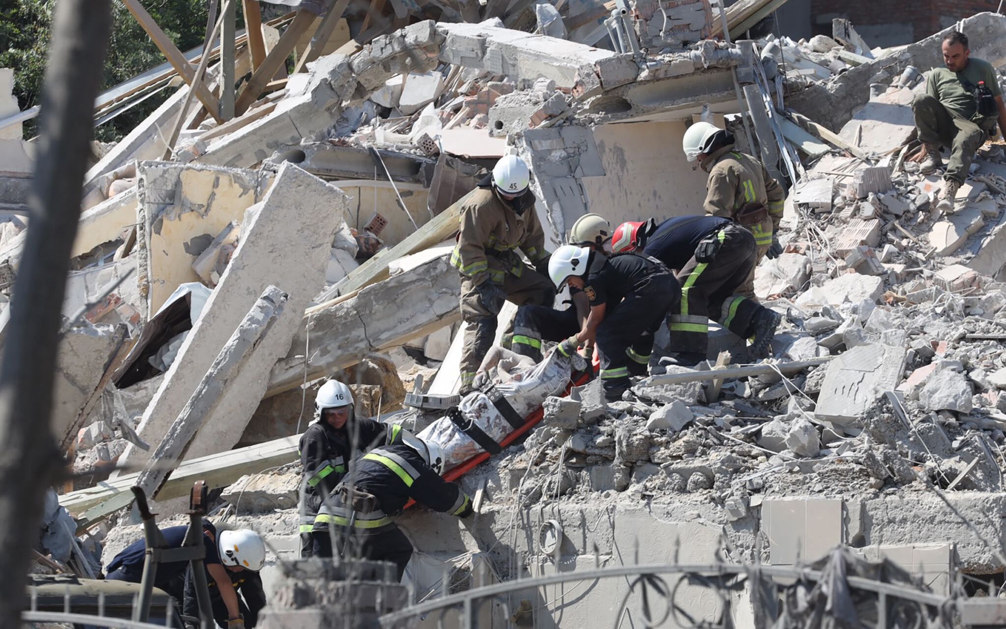 Rescuers evacuate the body of a person from a destroyed building after being hit by a missile strike in the Ukrainian town of Sergiyvka , near Odessa, killing at least 18 people and injuring 30, on July 1, 2022. - During the night from June 30 to July 1, 2022, two missiles were fired by a "strategic aircraft" from the Black Sea, hitting buildings, according to the Ukrainian emergency services. (Photo by Oleksandr GIMANOV / AFP)