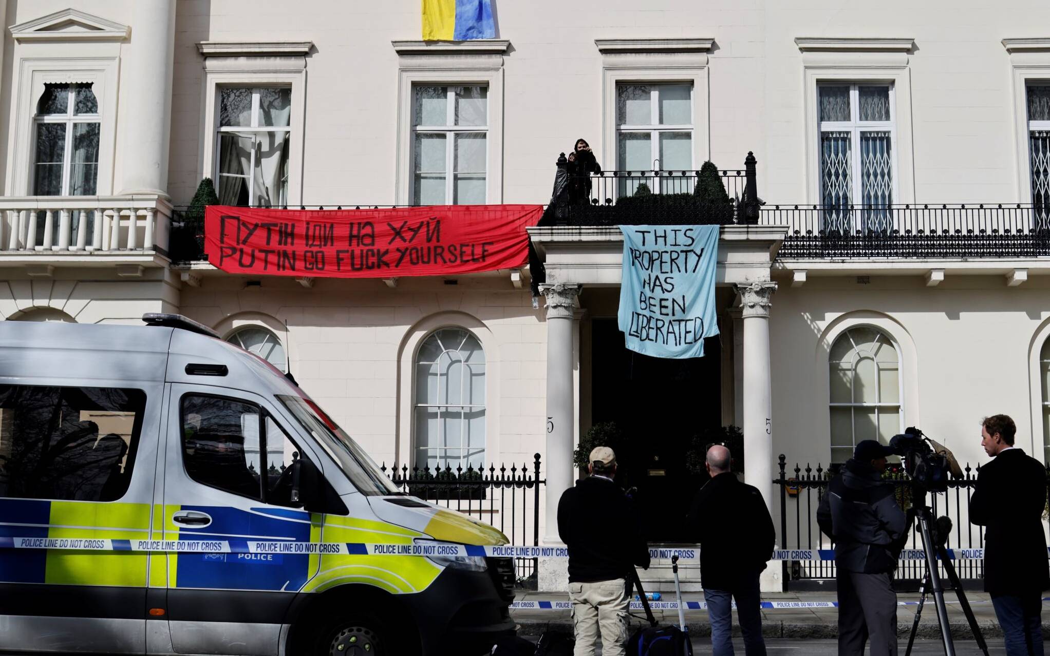 Journalists and police officers arrive at a mansion supposedly belonging to Russian oligarch Oleg Deripaska in Belgrave Square, central London, on March 14, 2022 that is occupied by a group of squatters. - Oleg Deripaska is one of the seven Russian oligarchs who have been sanctioned by Britain's   Government. (Photo by Tolga Akmen / AFP)