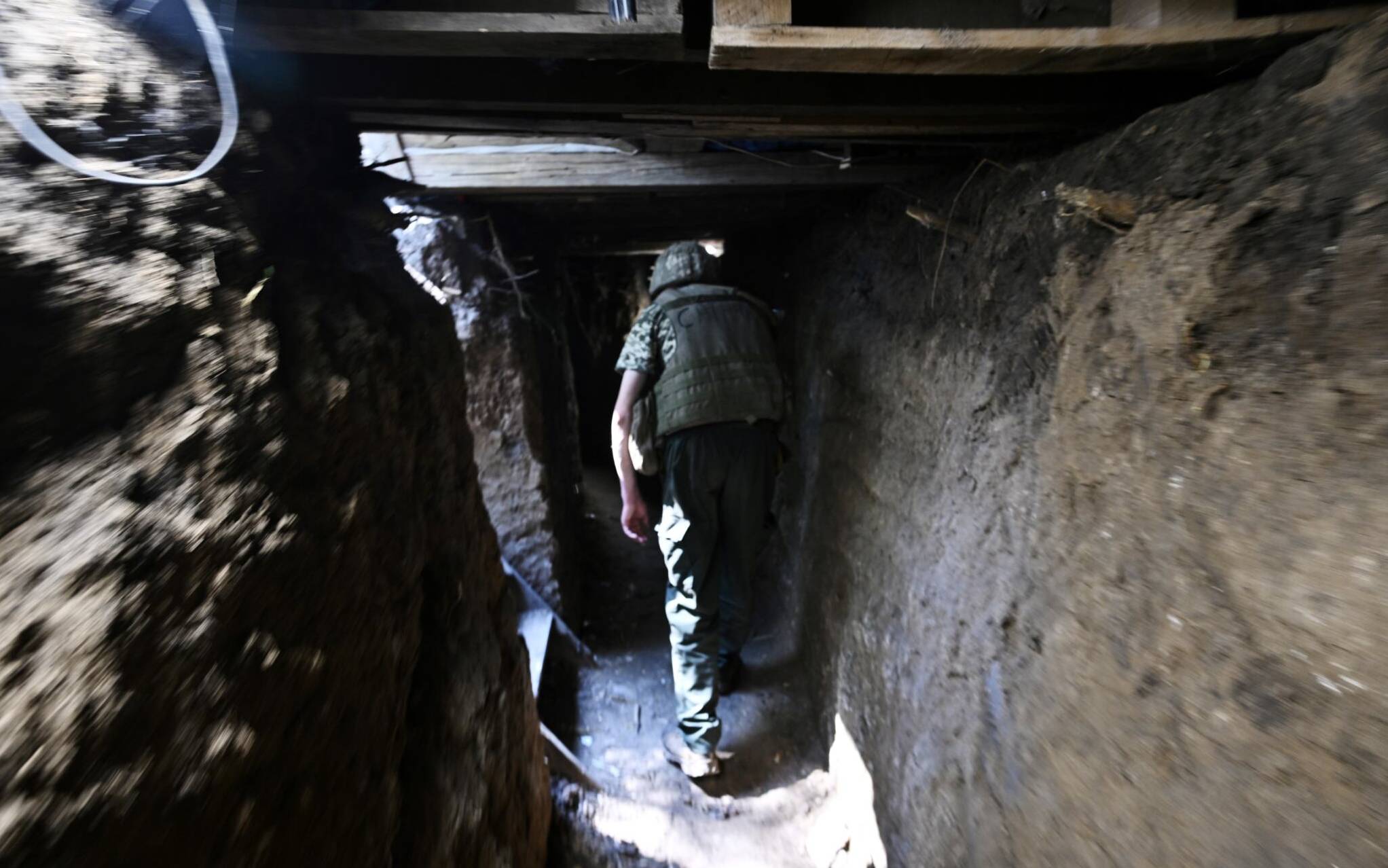 A Ukrainian serviceman walks through a tunnel of a trench on a position held by the Ukrainian army between southern cities of Mykolaiv and Kherson on June 12, 2022, amid the Russian invasion of Ukraine. (Photo by Genya SAVILOV / AFP)