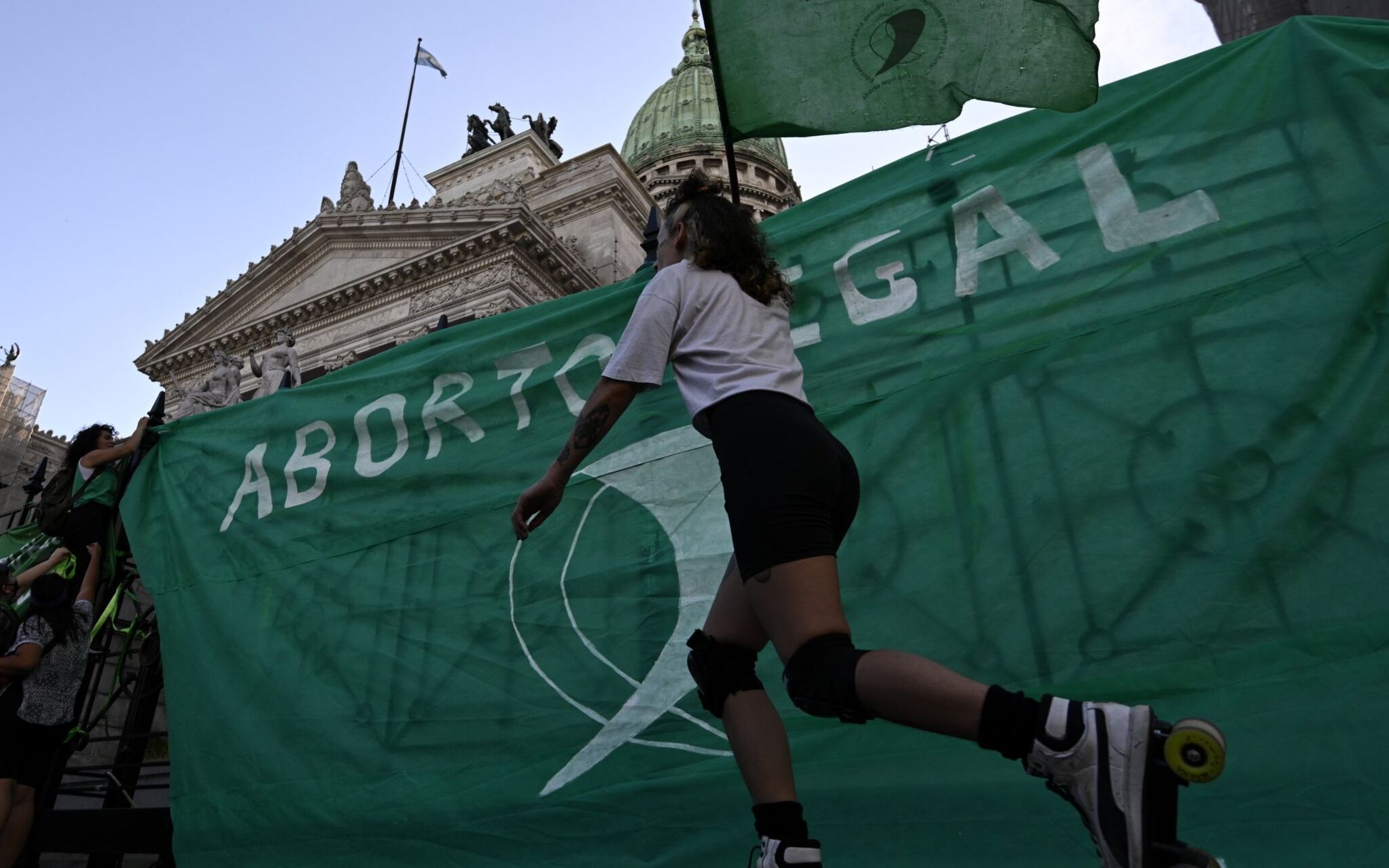 An activist holding a flag reading Legal Abortion skates during a demo outside the Congress building in Buenos Aires, on November 18, 2020, a day after Argentina's President Alberto Fernandez announced on Twitter that he will send an abortion legalization bill to the Congress, amid the new coronavirus pandemic. (Photo by JUAN MABROMATA / AFP)
