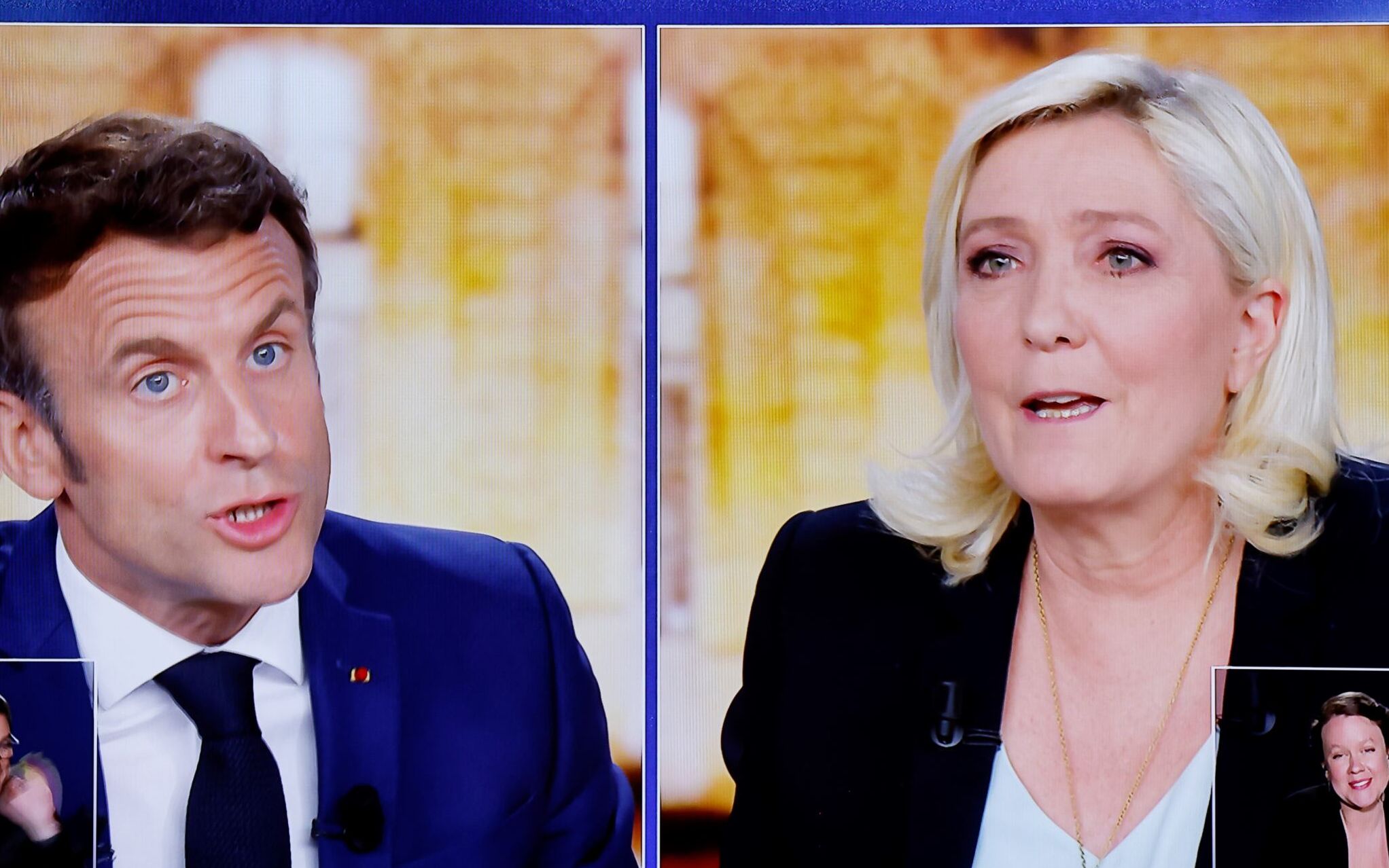 A picture shows a TV screen  displaying a live televised between French President and La Republique en Marche (LREM) party candidate for re-election Emmanuel Macron (L) and French far-right party Rassemblement National (RN) presidential candidate Marine Le Pen (R), broadcasted on French TV channels TF1 and France 2, in Saint-Denis, north of Paris, ahead of the second round of France's presidential election. - French voters head to the polls for a run-off vote between Macron and Le Pen on April 24, 2022. (Photo by Ludovic MARIN / AFP)