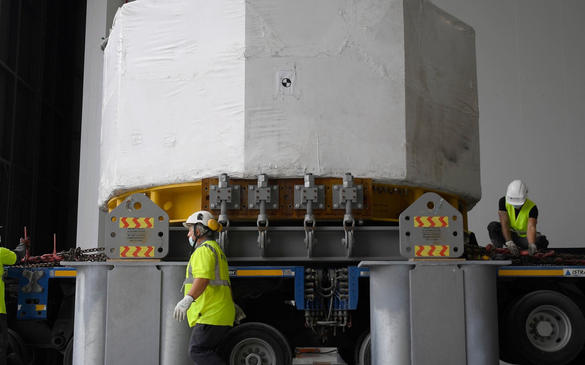 Engineers work around the world's most powerful magnet as it is delivered at the international nuclear fusion project Iter in Saint-Paul-les-Durance, southern France, on September 9, 2021. (Photo by Nicolas TUCAT / AFP)