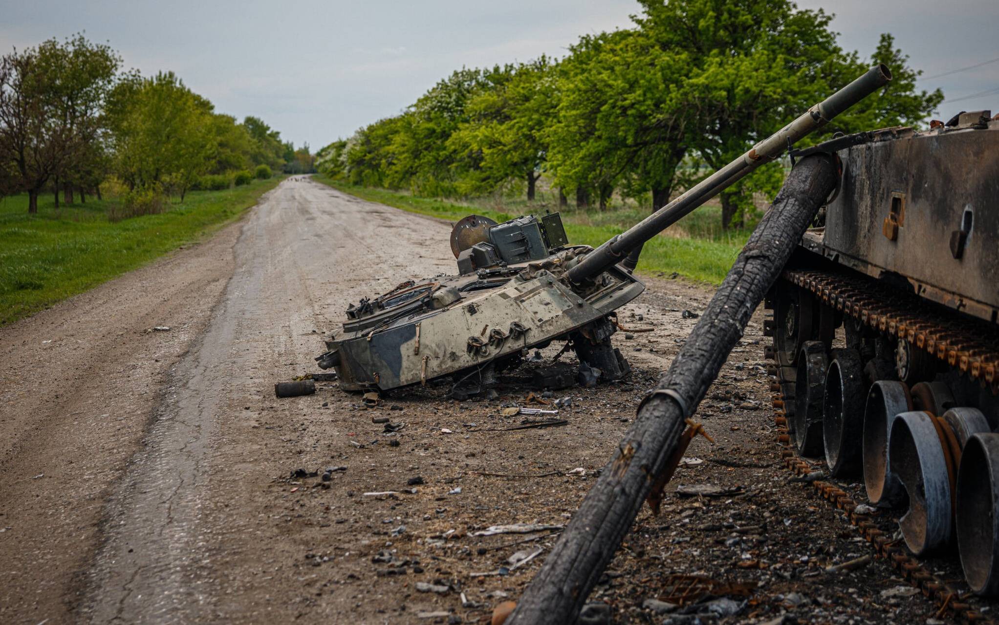 A photograph taken on May 4, 2022 shows a destroyed Russian BMP-3 infantry fighting vehicle on a road near Pokrovske, eastern Ukraine amid the Russian invasion of Ukraine. - The blaze in a football field-length storage building has been burning at least a day  but there's no firefighters in Temyrivka because everyone has evacuated, leaving the black smoke to rises unhurriedly. That village is in a no man's land where the two sides are so close, in some places about 3 kms, that Ukrainian troops using binoculars can see the Russians digging at their positions. (Photo by Dimitar DILKOFF / AFP)