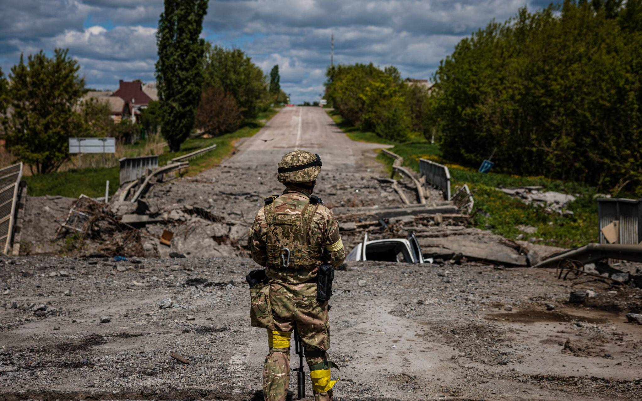 A soldier of the Kraken Ukrainian special forces unit observes the area at a destroyed bridge on the road near the village of Rus'ka Lozova, north of Kharkiv, on May 16, 2022. - Ukraine has said its troops have regained control of territory on the Russian border near the country's second-largest city of Kharkiv, which has been under constant fire since Moscow's invasion began. (Photo by Dimitar DILKOFF / AFP)