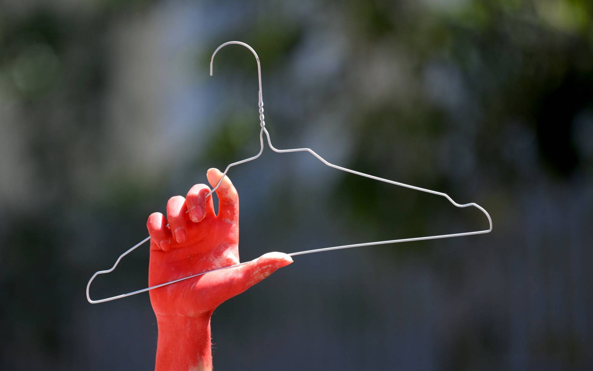 A participant with a bloody hand holds a clothes hanger in reference to abortion during the annual Pride Parade in Marseille, southern France, on July 2, 2022. (Photo by Nicolas TUCAT / AFP)