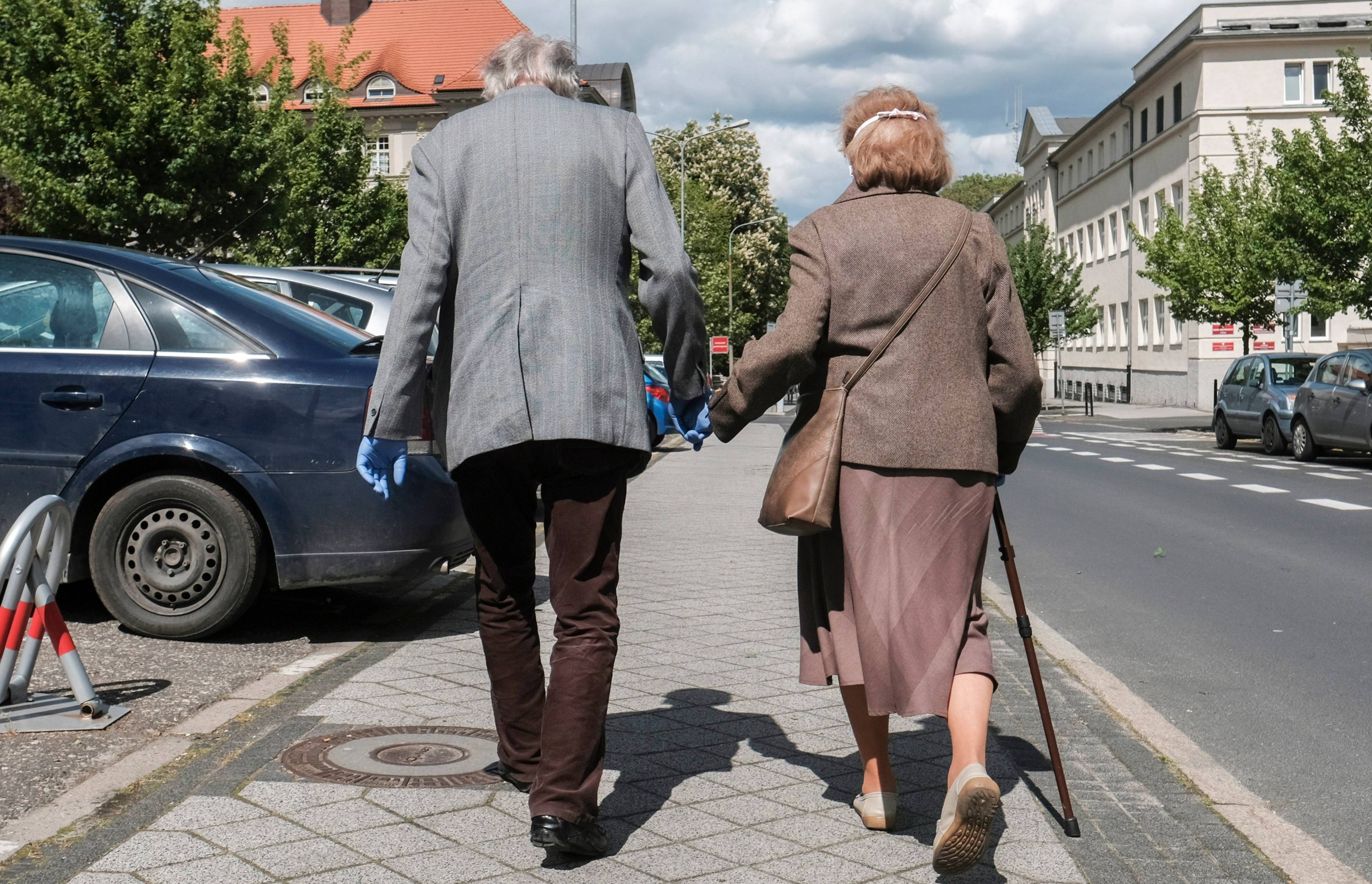 Dwoje emerytów na spacerze. Trzymają się za ręce