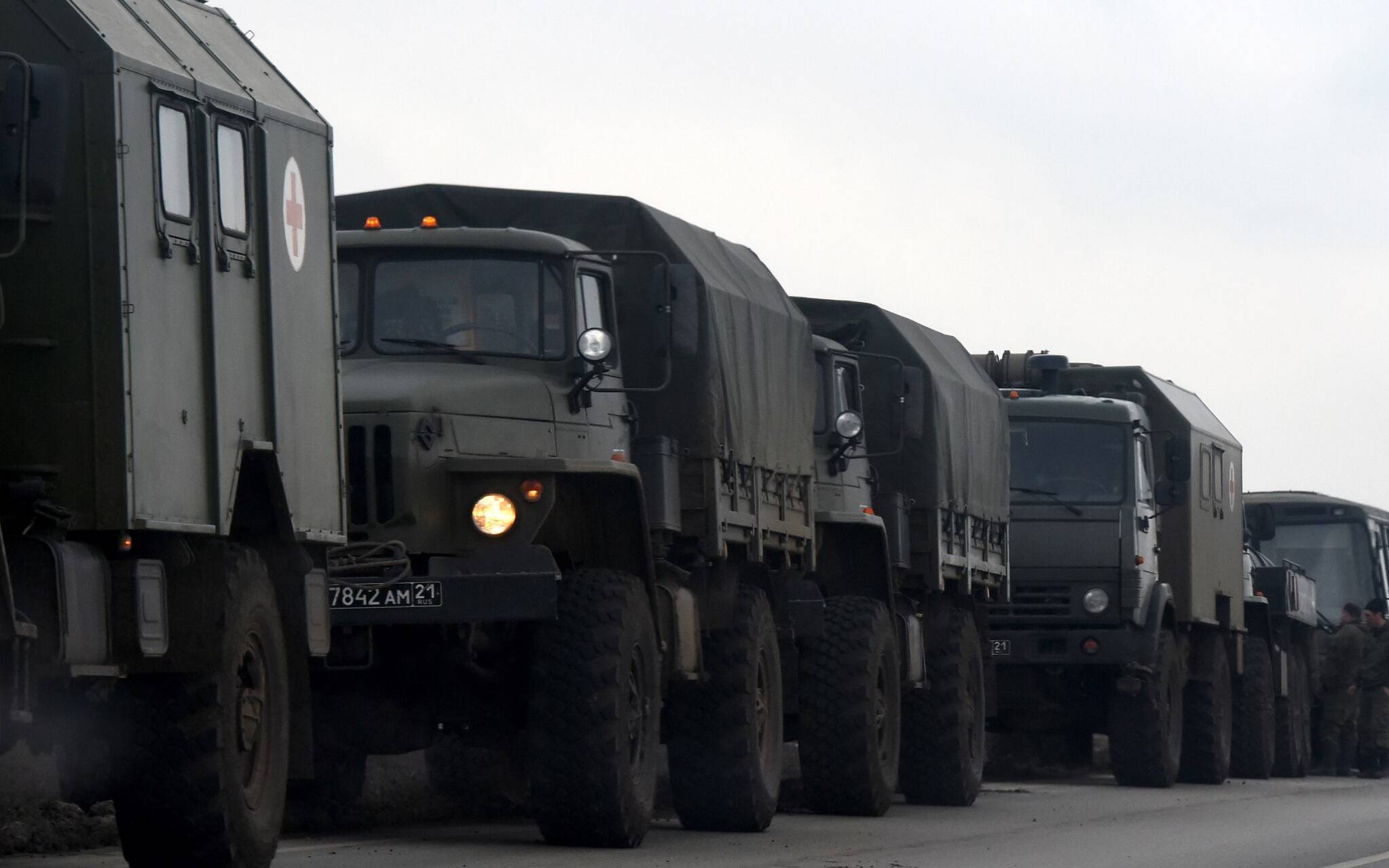 Russian military trucks and buses are seen on the side of a road in Russia's southern Rostov region, which borders the self-proclaimed Donetsk People's Republic, on February 23, 2022. (Photo by STRINGER / AFP)