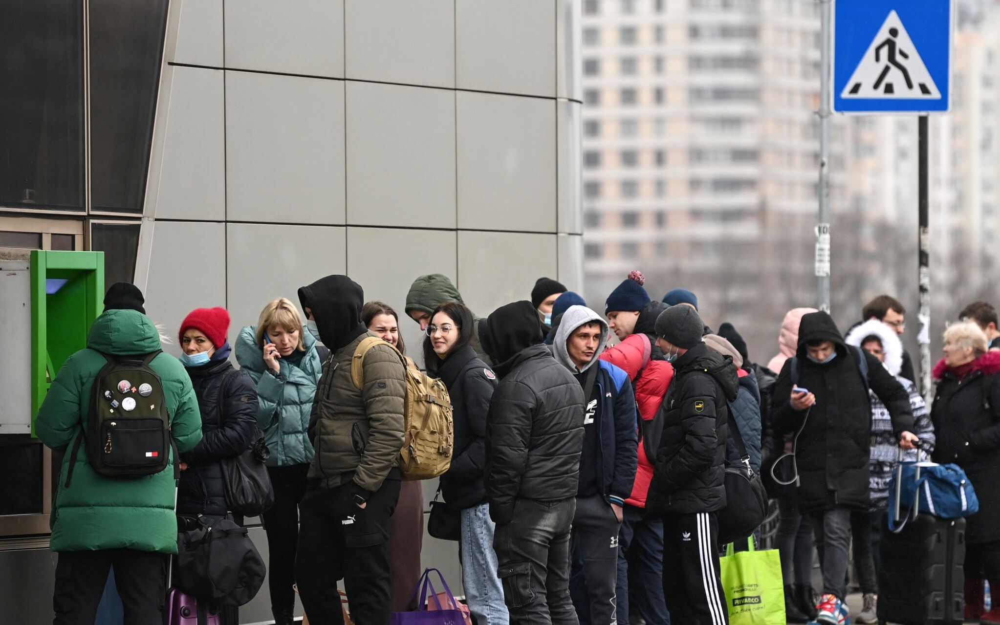 People line up to withdraw money at a cash dispenser in Kyiv in the morning of February 24, 2022. 
Air raid sirens rang out in downtown Kyiv today as cities across Ukraine were hit with what Ukrainian officials said were Russian missile strikes and artillery. - Russian President announced a military operation in Ukraine on February 24, 2022, with explosions heard soon after across the country and its foreign minister warning a "full-scale invasion" was underway. (Photo by Daniel LEAL / AFP)