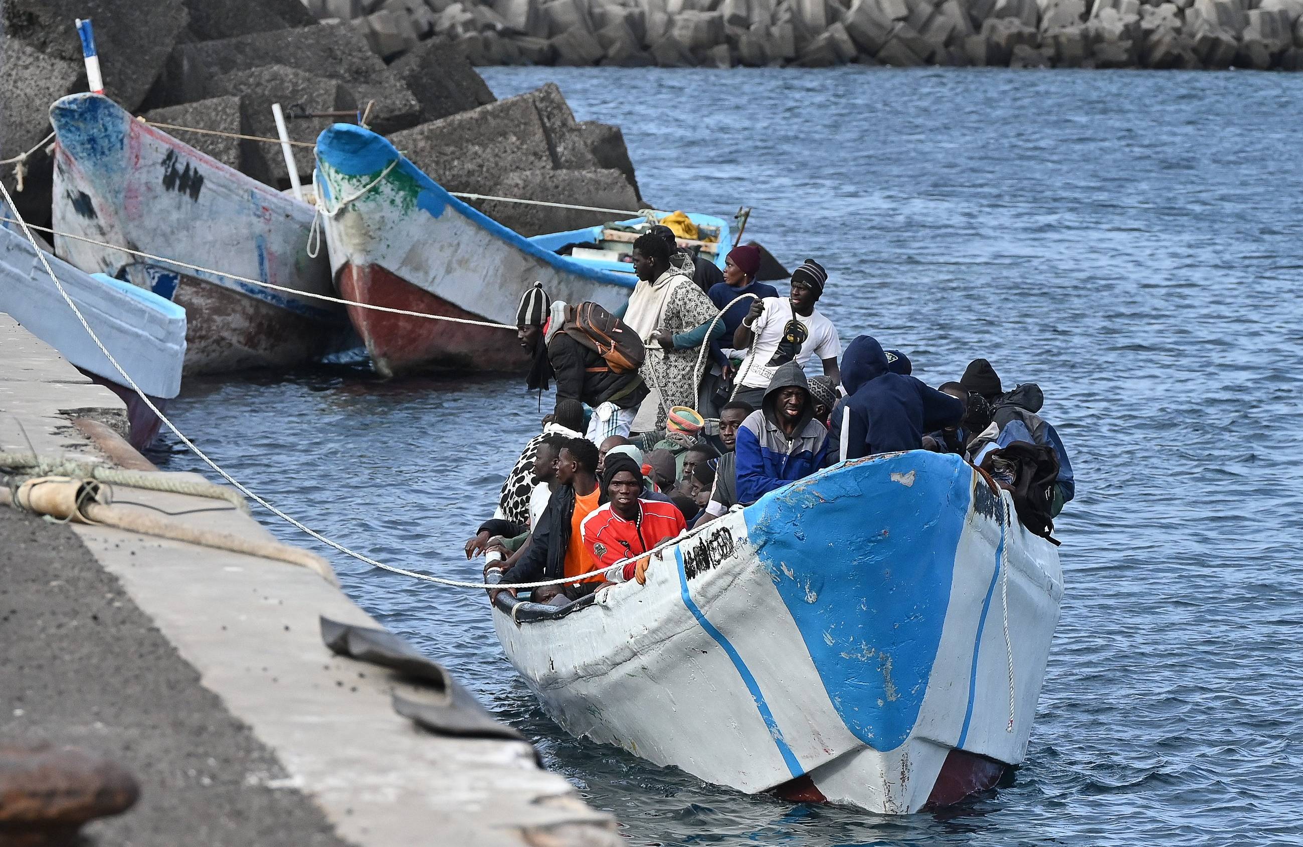 Dobijająca do brzegu łódź pełna migrantów z Afryki. Pakt migracyjny