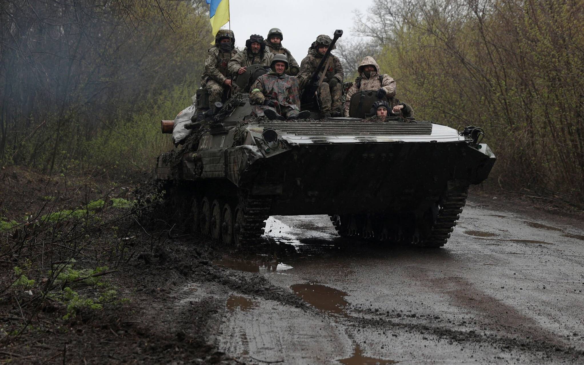 Ukrainian soldiers stand on an armoured personnel carrier (APC), not far from the front-line with Russian troops, in Izyum district, Kharkiv region on April 18, 2022, during the Russian invasion of Ukraine. (Photo by Anatolii Stepanov / AFP)