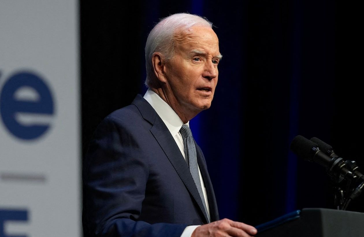 Joe Biden podczas przemówienia. Obok na banerze duży napis po angielsku: vote to live