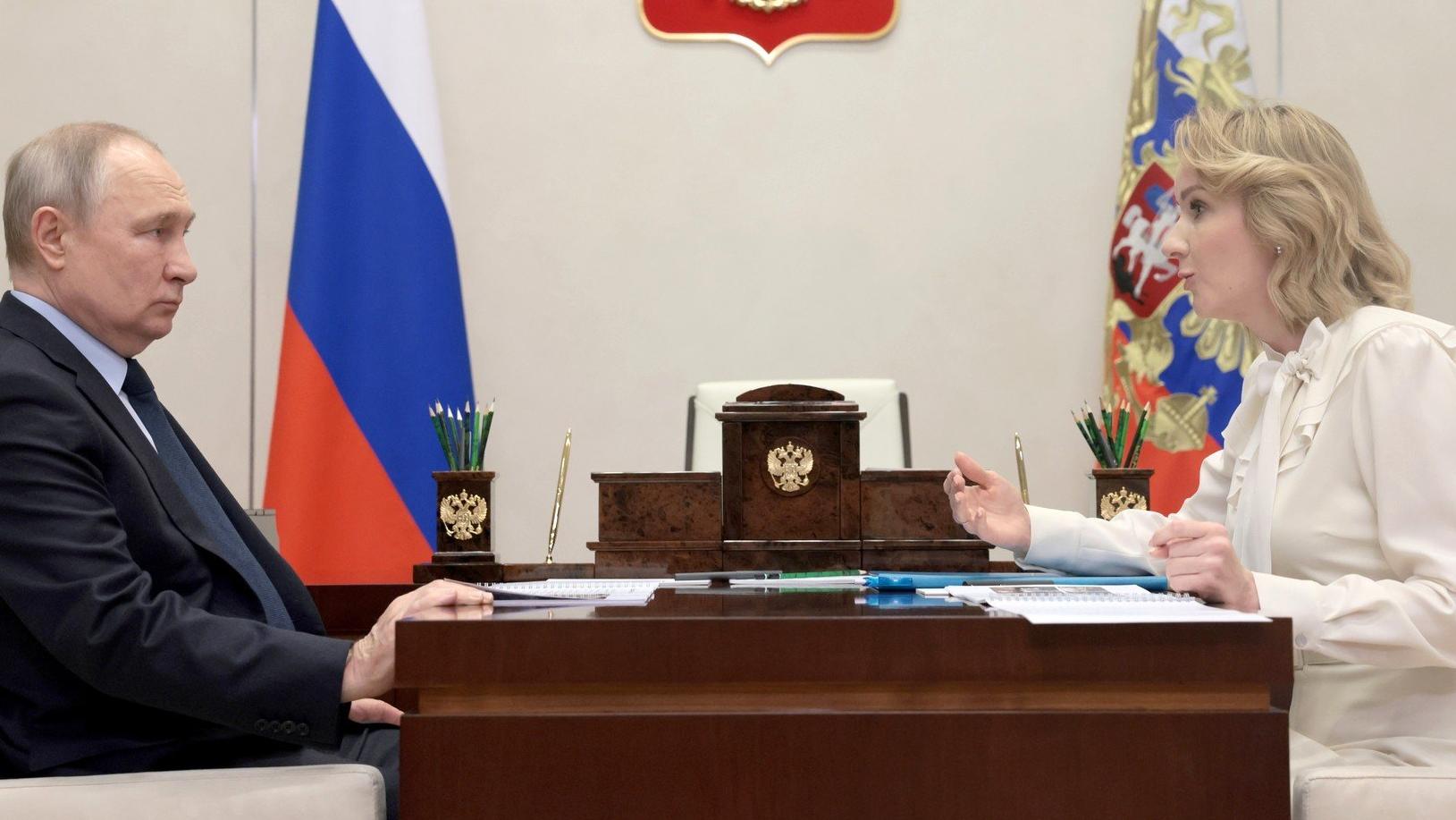 Na zdjęciu prezydent Rosji siedzi naprzeciw kobiety, Marii Lwowej-Biełowej