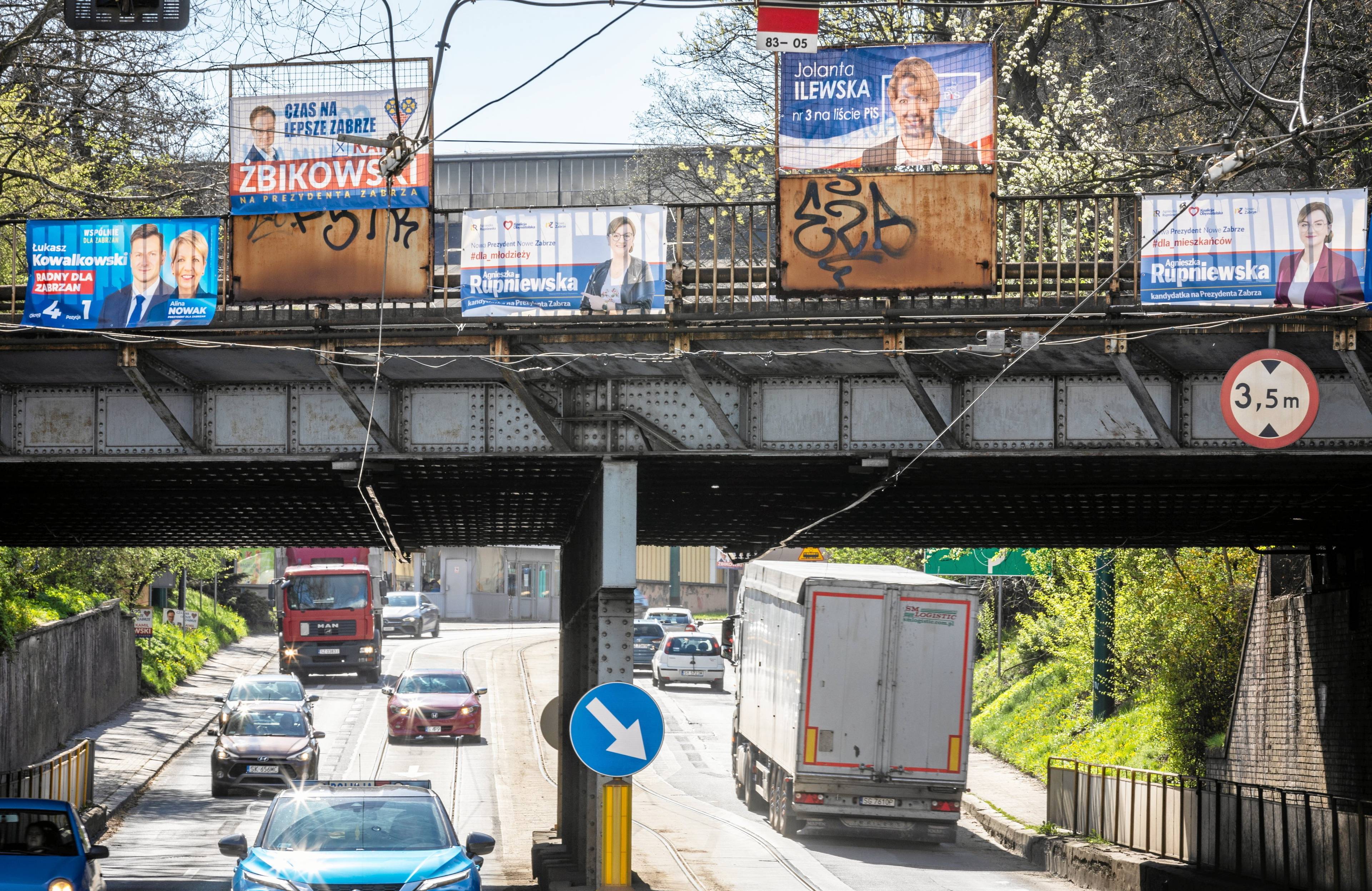 Widok na wiadukt drogowy oklejonym plakatami wyborczymi