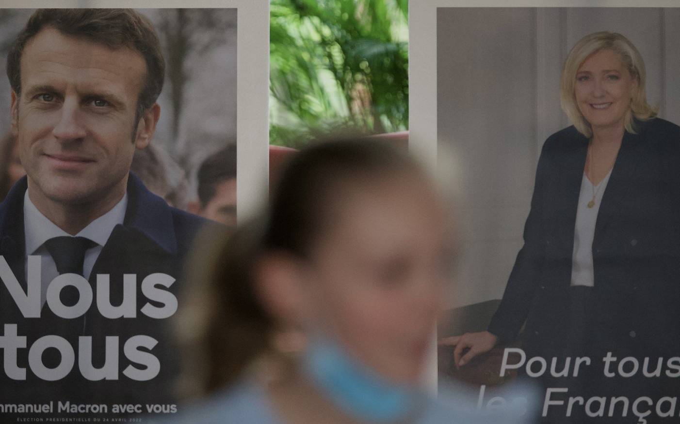 Pictures of candidates Emmanuel Macron (L) and Marine Le Pen are displayed during the second round of voting in the French presidential elections at the French Embassy in Beijing on April 24, 2022. (Photo by Noel Celis / AFP)