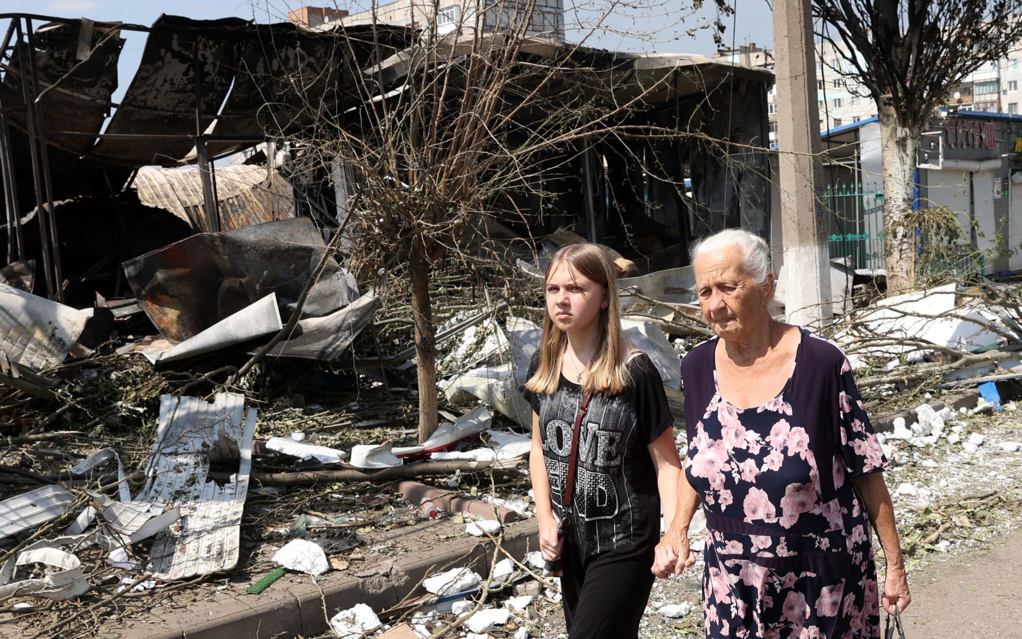 Two person walk among the debris of a destroyed local market after a Russian missile strike in the town of Bakhmut, Donetsk region on July 16, 2022 amid Russian military invasion of Ukraine. (Photo by Anatolii Stepanov / AFP)