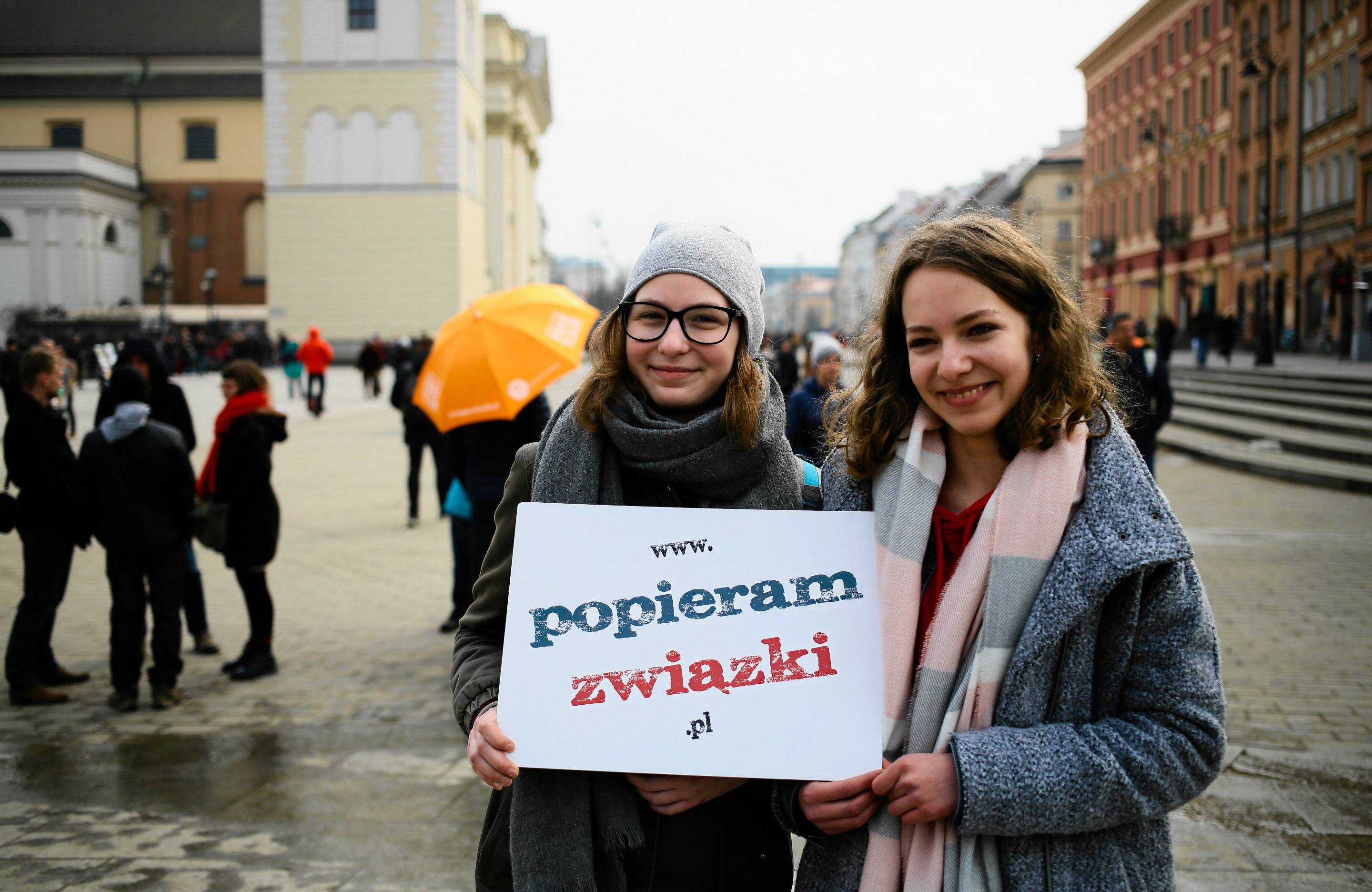 Dwie kobiety trzymają w rękach planszę z napisem Popieram związki