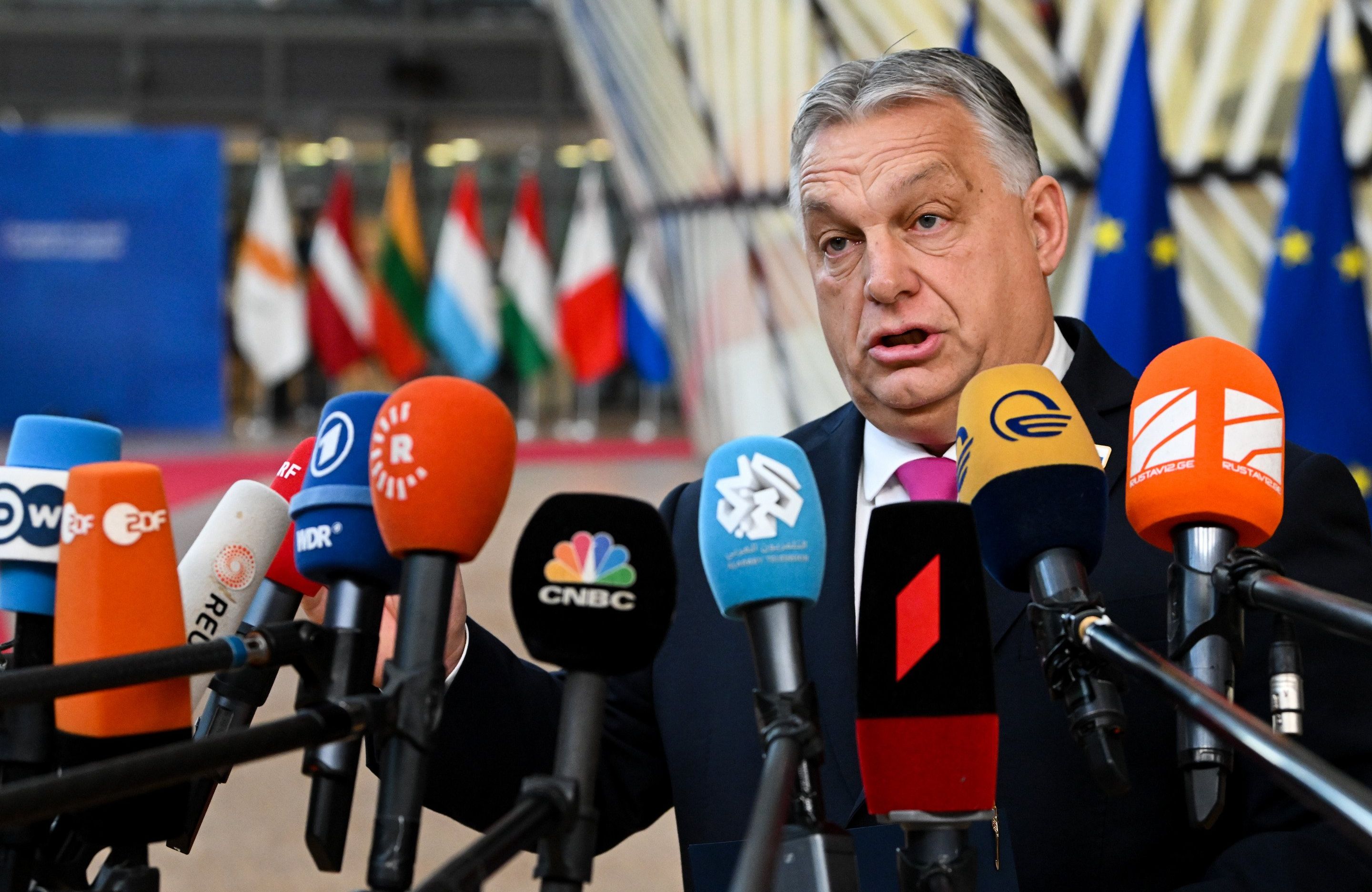 Mężczyzna z krótkimi szpakowatymi włosami wypowiada się do kilkunastu mikrofonów różnych mediów
