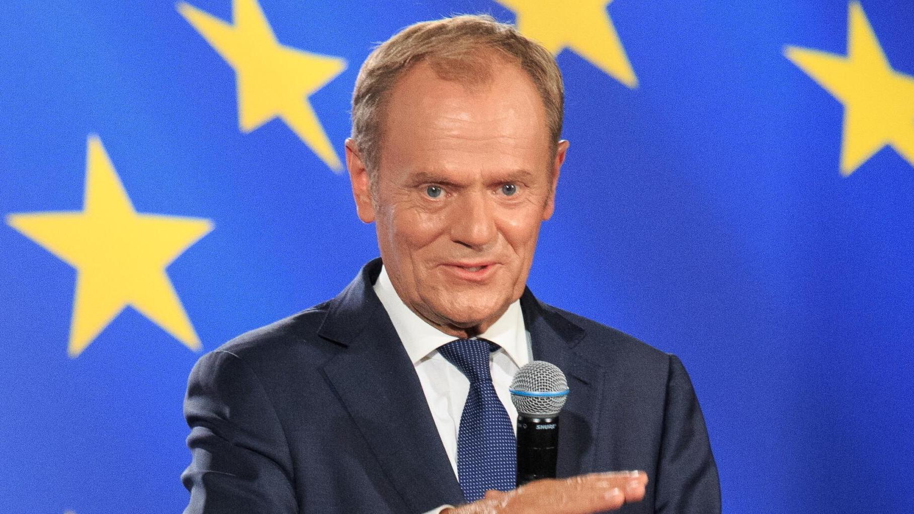 Donald Tusk na tle unijnej flagi