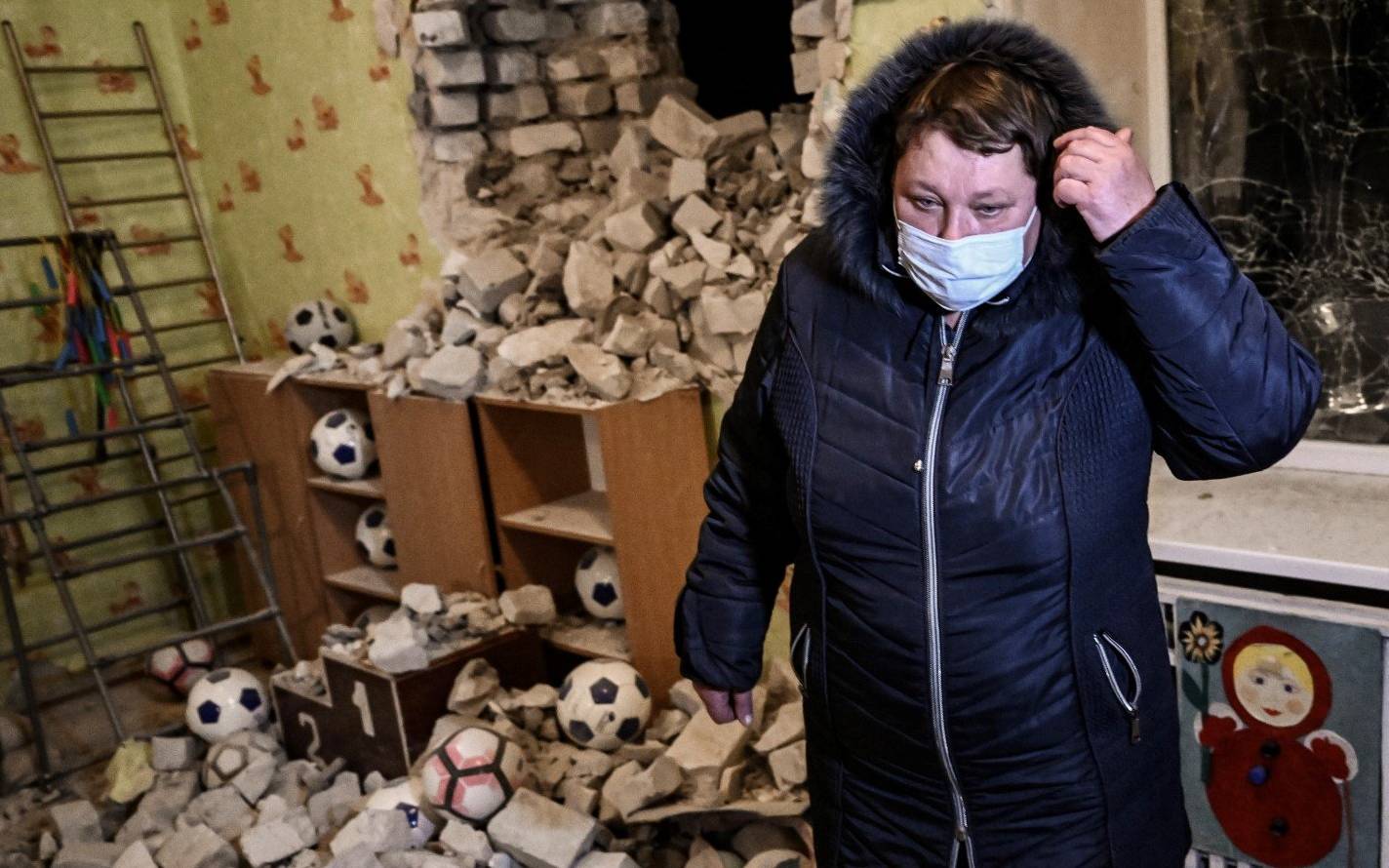 A woman stands inside among debris after the reported shelling of a kindergarden in the settlement of Stanytsia Luhanska, Ukraine, on February 17, 2022. - U.S. Defence Secretary Lloyd Austin warned on February 17, 2022, of a provocation by Moscow to justify military intervention in Ukraine after "disturbing" reports of mutual accusations of bombing between the Ukrainian military and pro-Russian separatists. (Photo by Aris Messinis / AFP)