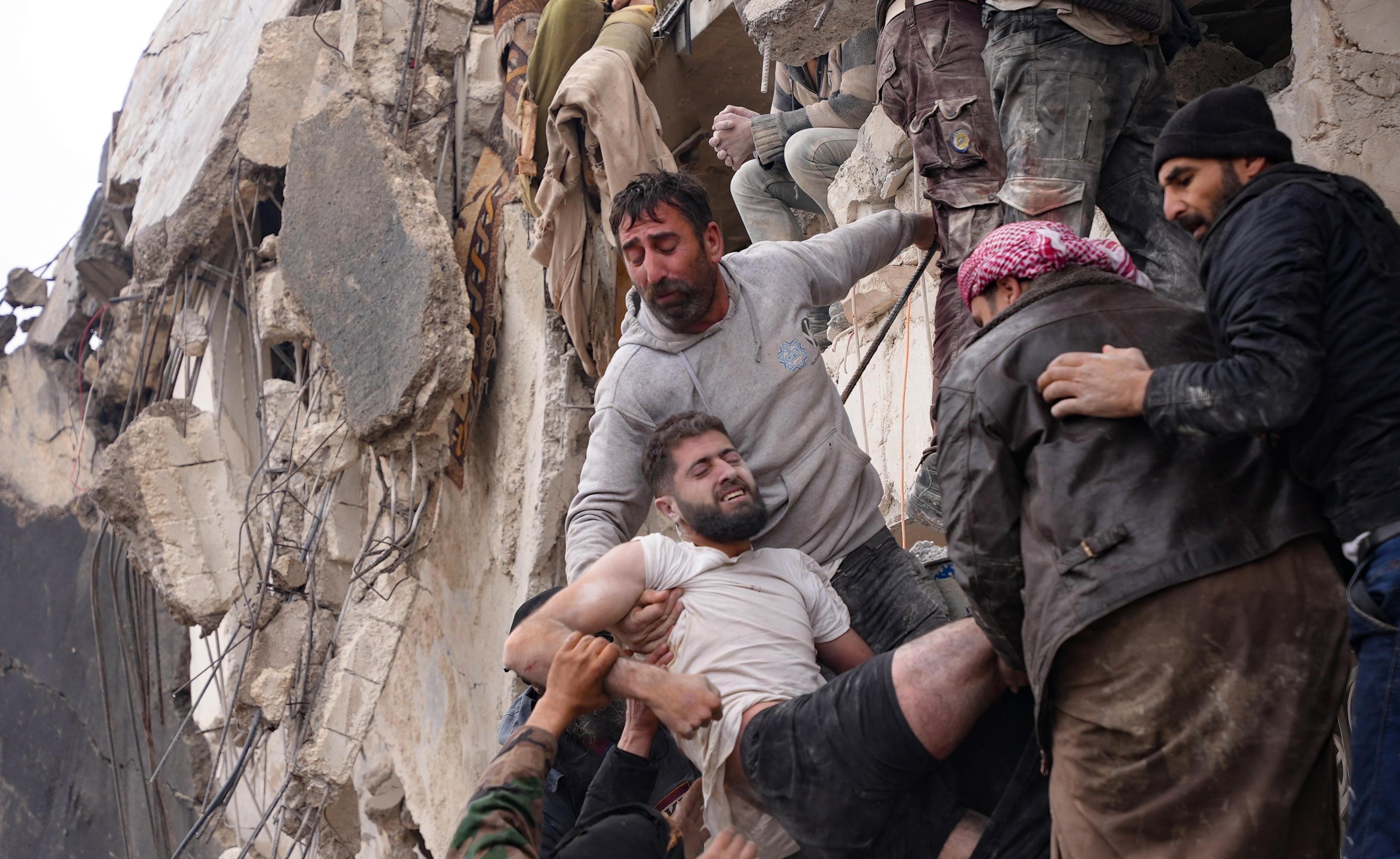 Ofiary trzęsienia ziemi w Syrii i Turcji wynoszone ze ruin zawalonego budynku