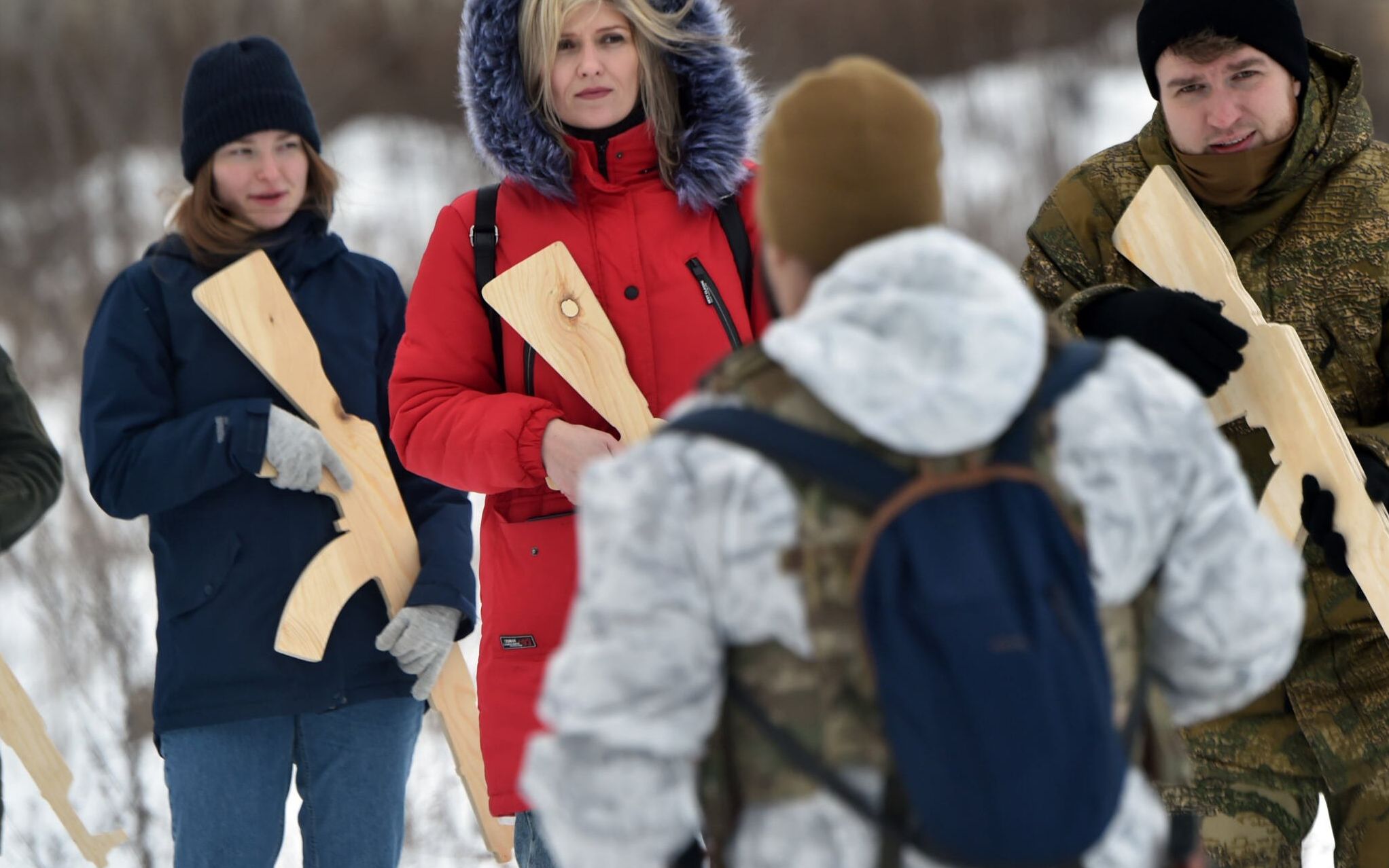 A military instructor teaches civilians holding wooden replicas of Kalashnikov rifles, as they take part in a training session at an abandoned factory in the Ukrainian capital of Kyiv on February 6, 2022. - Amid fears of a potential invasion by Russian troops massed on Ukraine's border, within the framework of the training there were classes on tactics, paramedics, training on the obstacle course. The training is conducted by instructors with combat experience, members of the movement "Total Resistance". Ukraine's presidency on February 06, insisted the chance of resolving soaring tensions with Russia through diplomacy remained greater than that of an attack, as the US warned Moscow was stepping up preparations for an invasion. "An honest assessment of the situation suggests that the chance of finding a diplomatic solution for de-escalation is still substantially higher than the threat of further escalation," said presidency advisor Mykhailo Podolyak in a statement. (Photo by Sergei SUPINSKY / AFP)