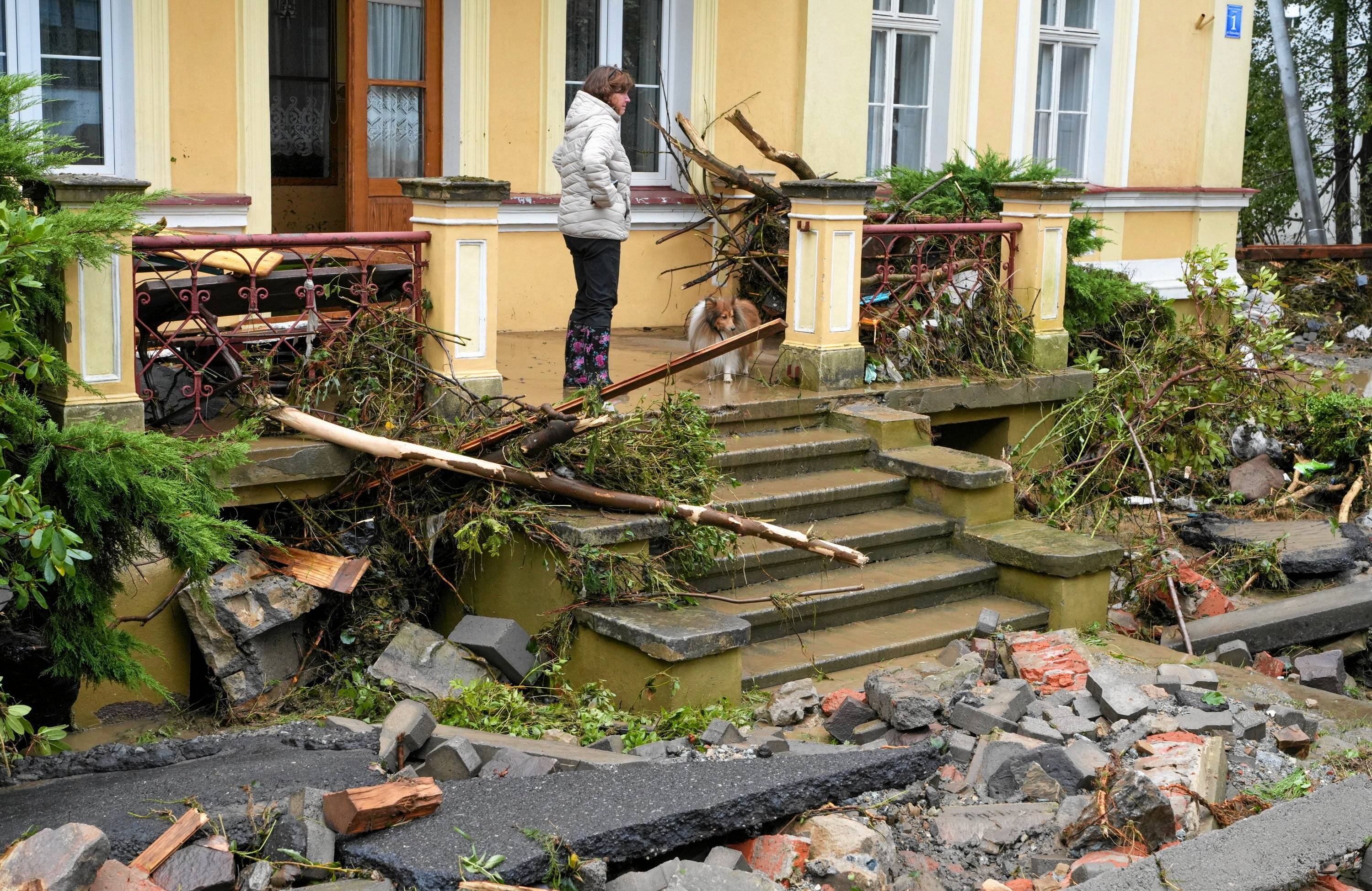 Gruz i gałęzie na chodniku po przejściu fali powodziowej