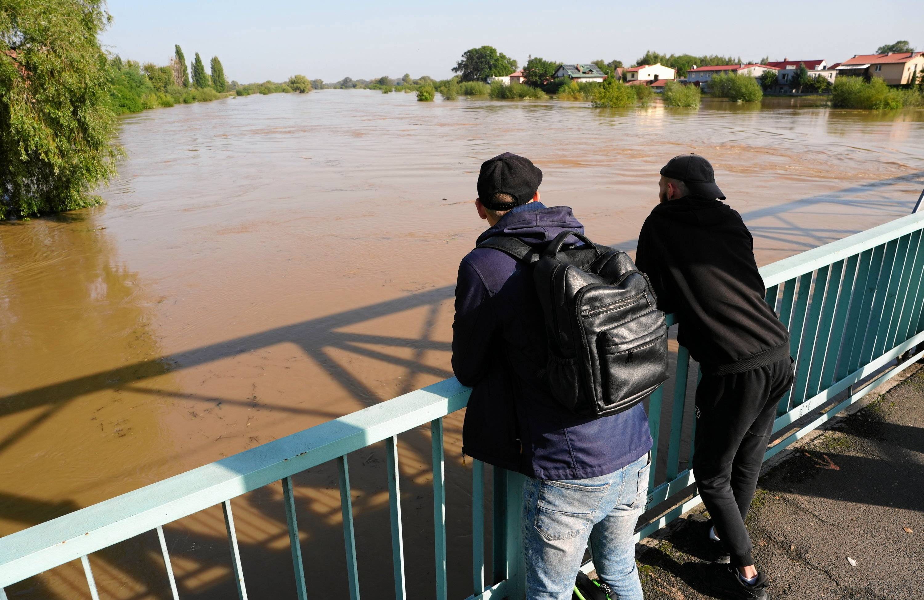 Dwaj mężczyźni obserwują wysoki stan Odry na moście w Oławie