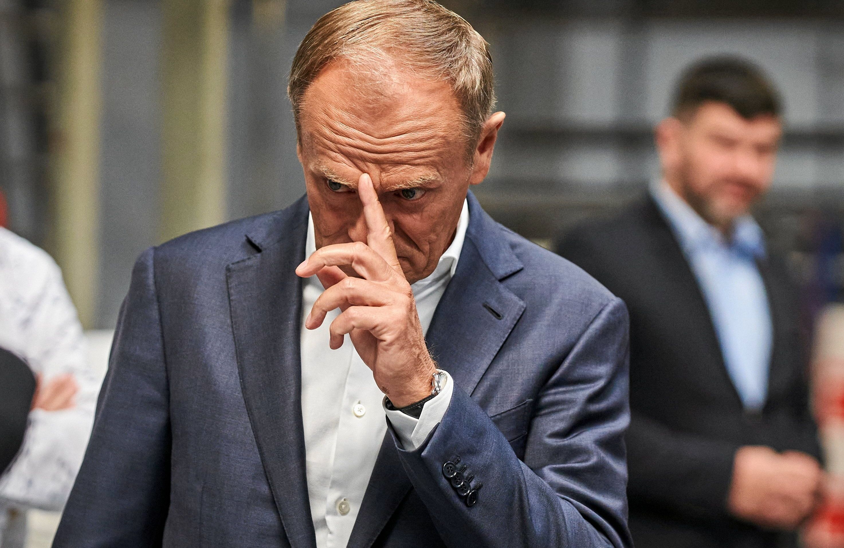 Donald Tusk dotykający czoła palcem wskazującym