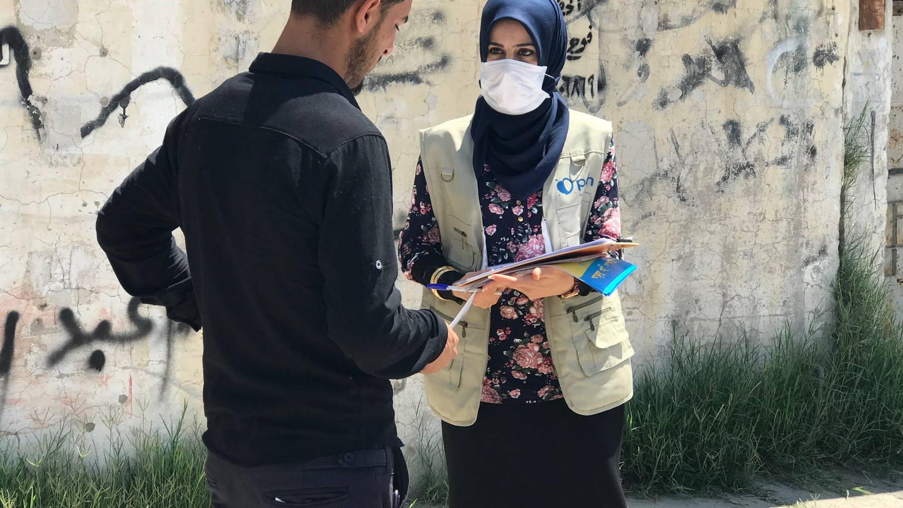 Pracownica PAH w Iraku rozmawia z przechodniem