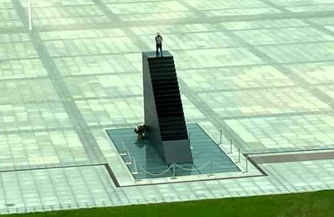 widok pomnika smoleńskiego na jego szczycie zamaskowany mężczyzna