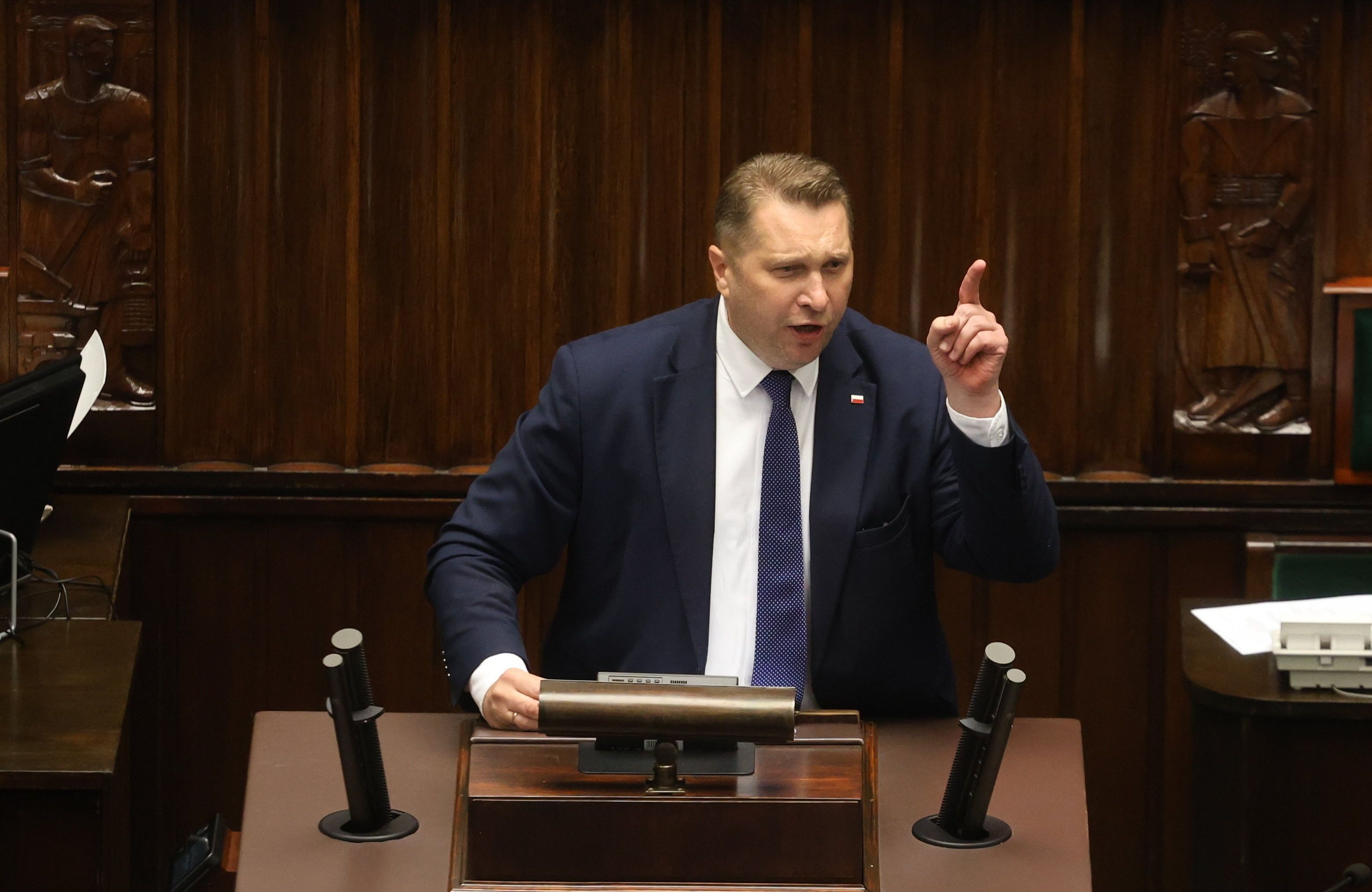Tęgi męzczyzna (Przemysław Czarnek) grozi palcem z trybuny sejmowej
