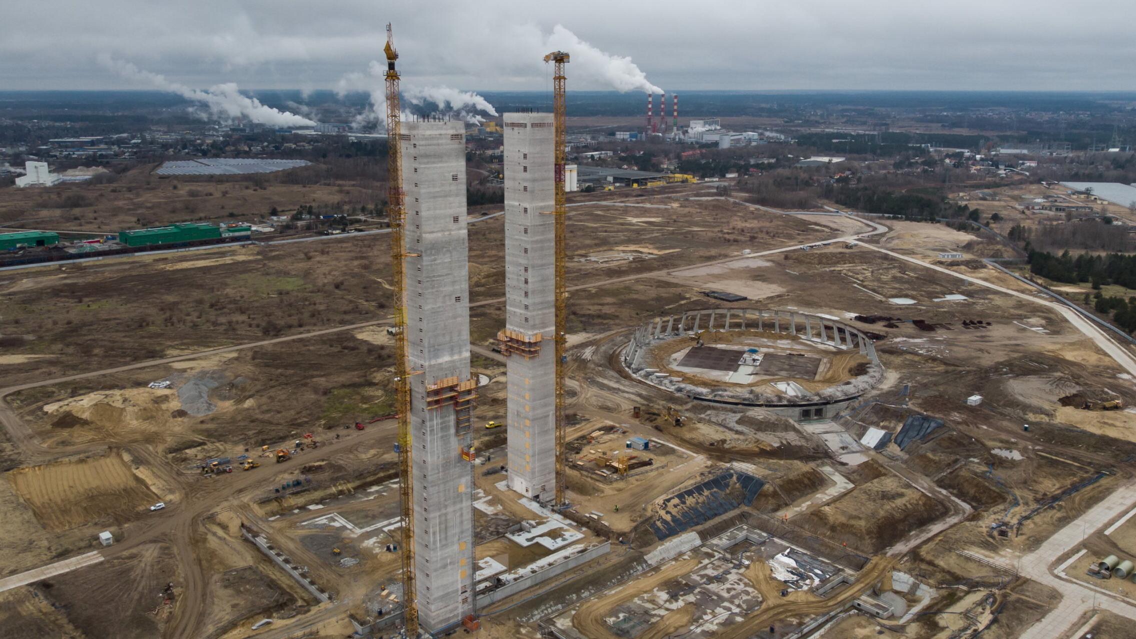 Widok z lotu ptaka teren budowy elektrowni, stoja dwie wieże chłodnicze