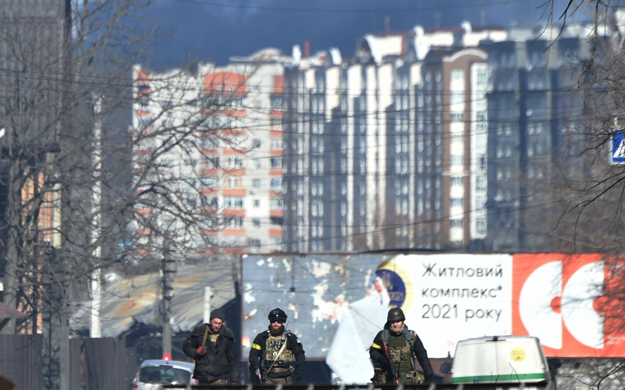 Ukrainian soldiers walk in Irpin, north of Kyiv, on March 12, 2022. - Russian forces stepped up the pressure on Kyiv on March 12, 2022. The northwest suburbs of the capital, including Irpin and Bucha, have already endured days of heavy bombardment while Russian armoured vehicles are advancing on the northeastern edge. (Photo by Sergei SUPINSKY / AFP)