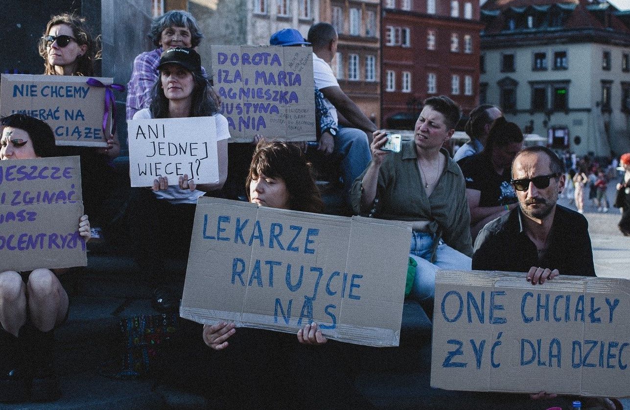 Ludzie trzymają transparenty: "Lekarze! Ratujcie nas", One chciały żyć dla dzieci"