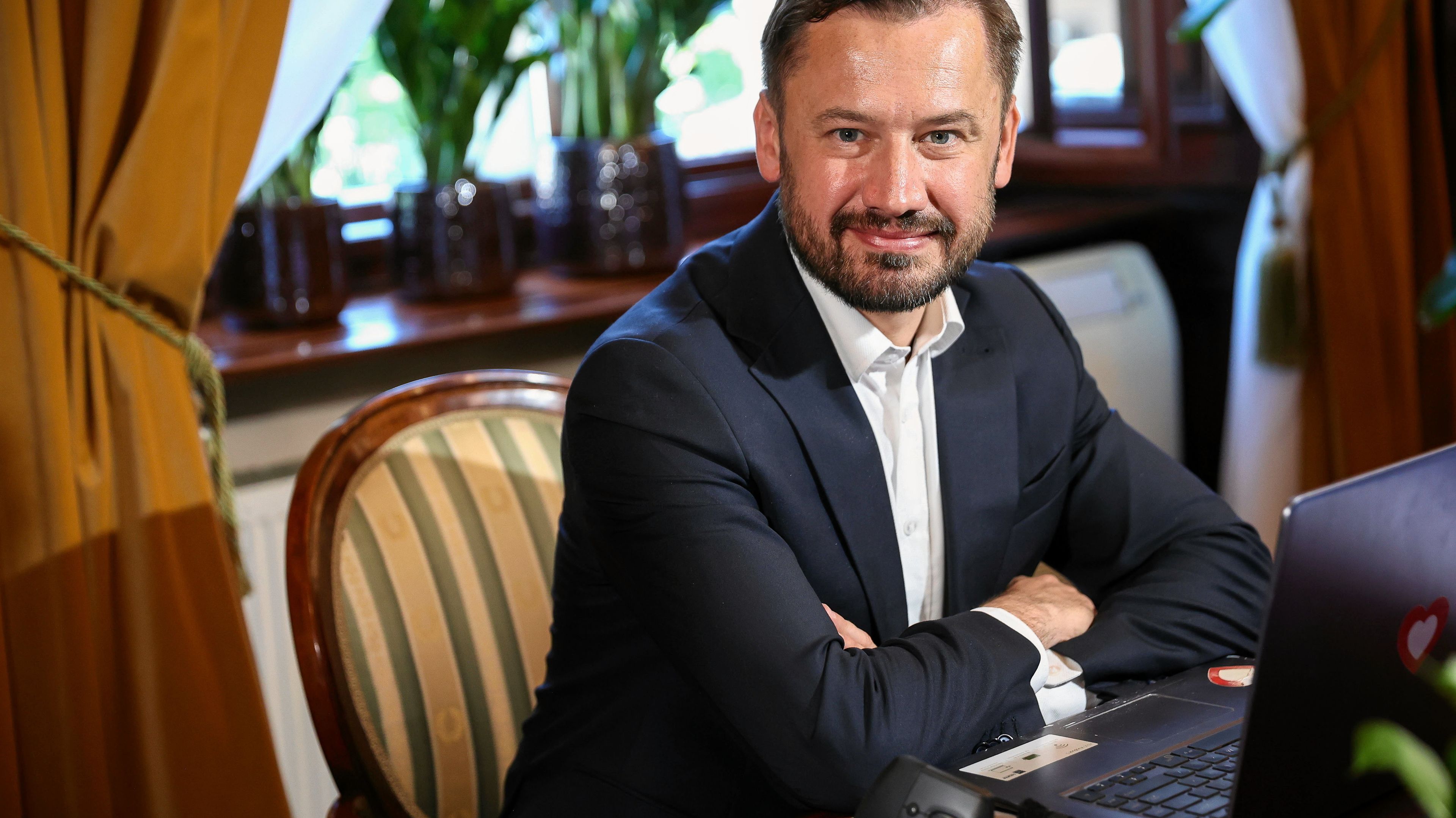 Elegancko ubrany mężczyzna siedzi przy biurku