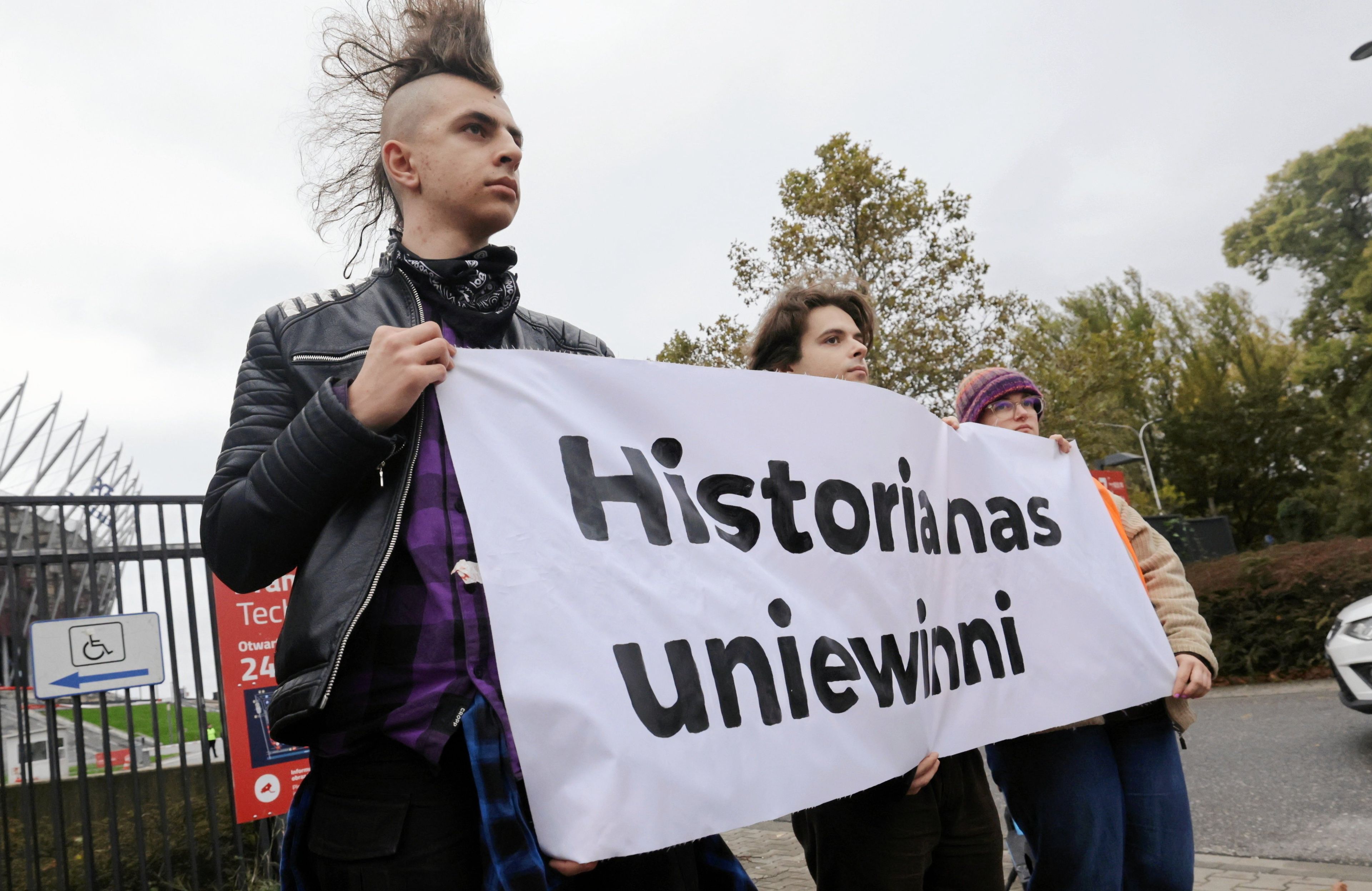 Aktywiści trzymają banaer z napisem "Historia nas uniwinni"